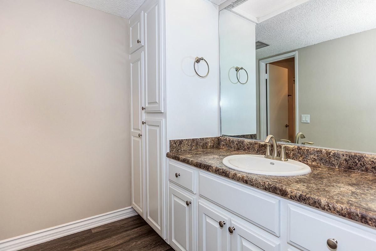 Bathroom with white cabinets and a mirror