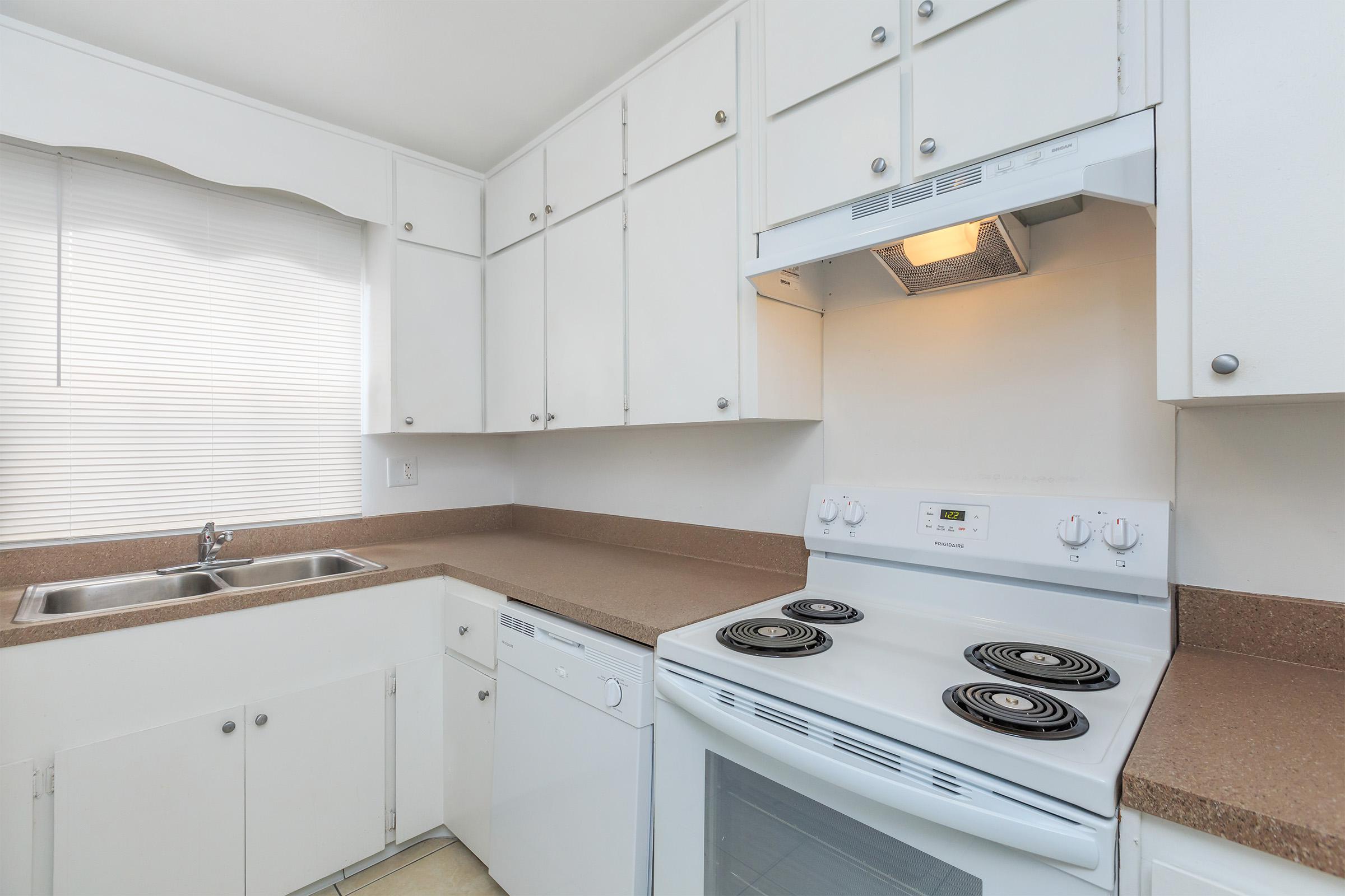 a white stove top oven sitting inside of a kitchen