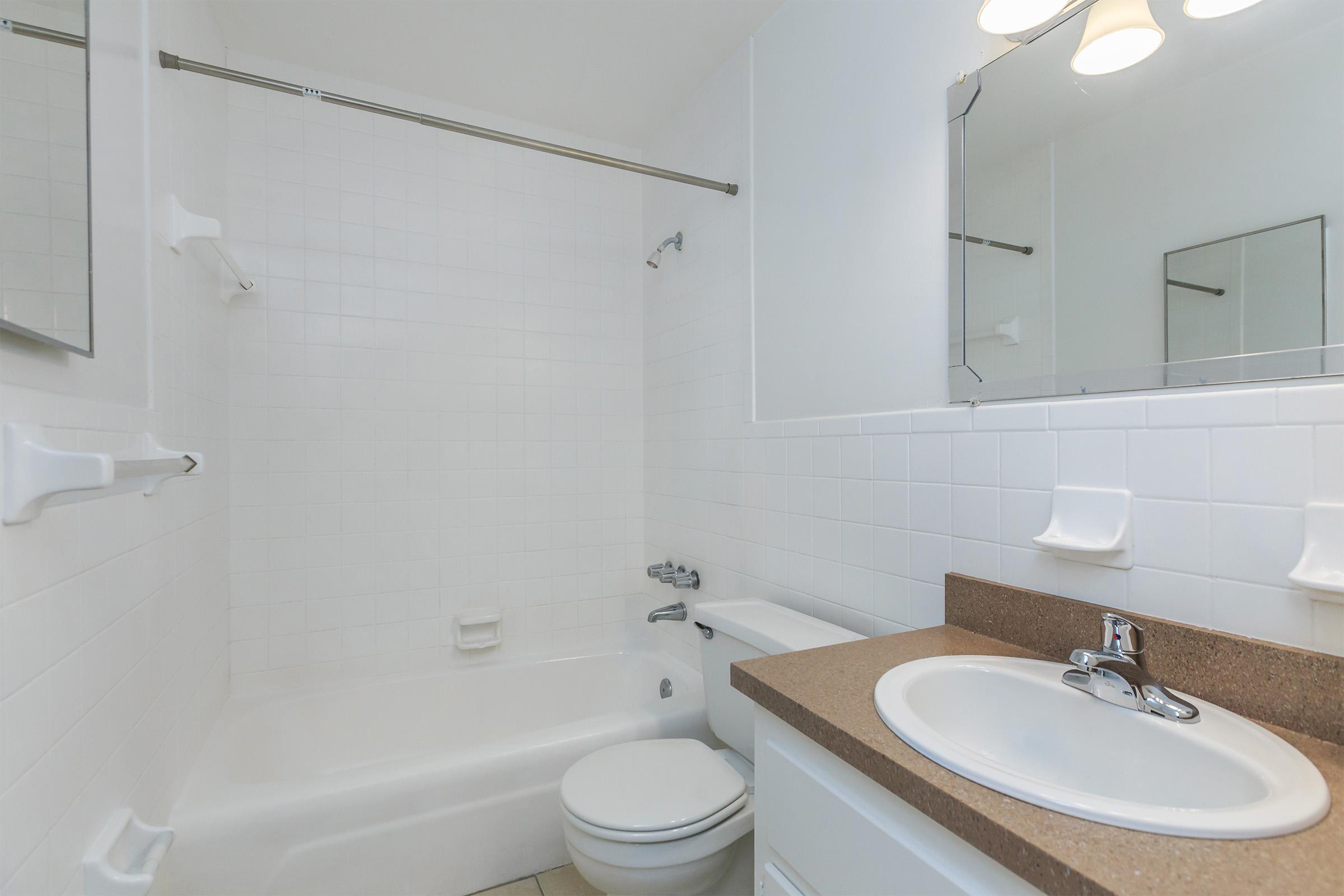 a white sink sitting under a mirror