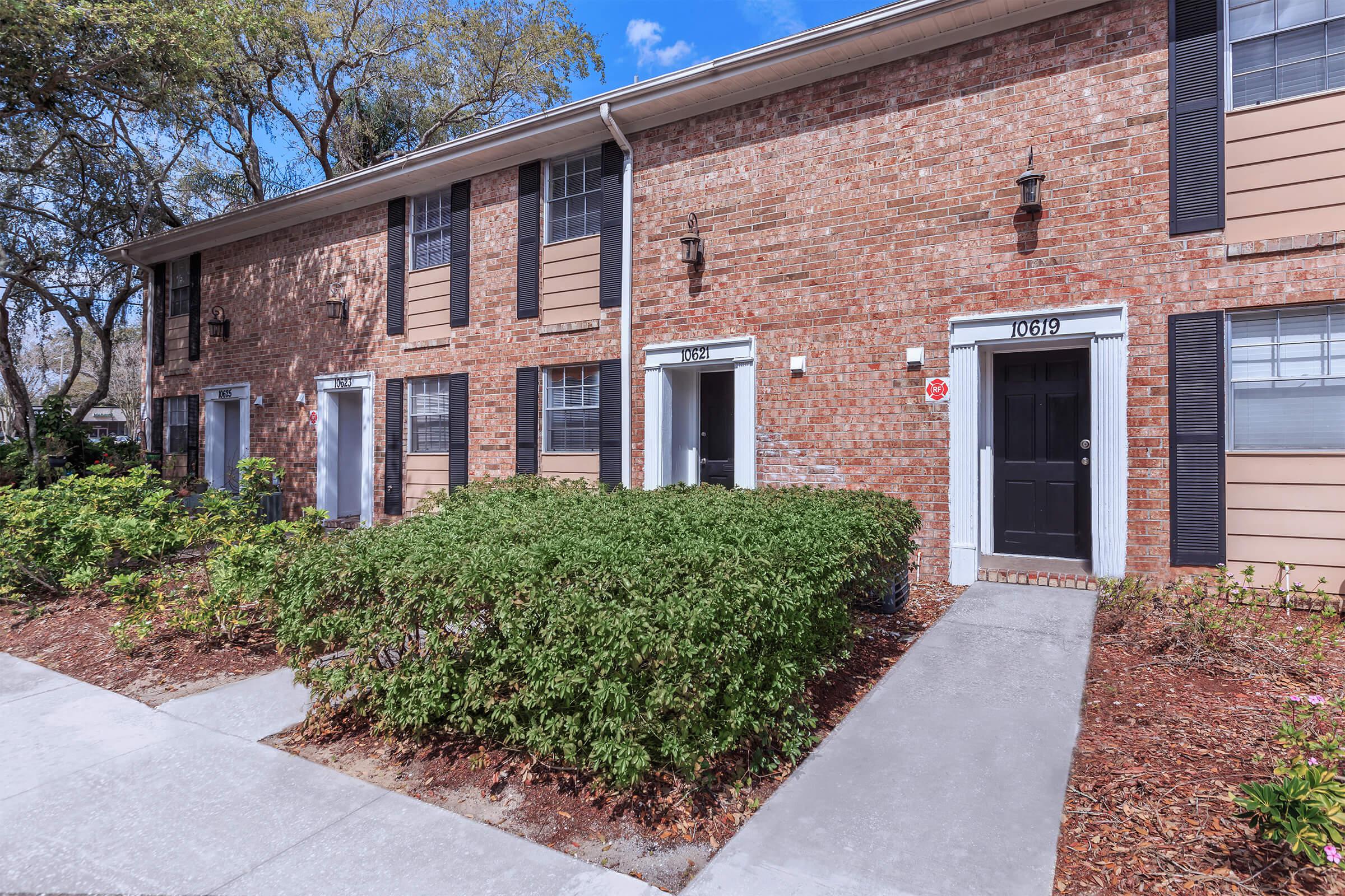 a house in front of a brick building