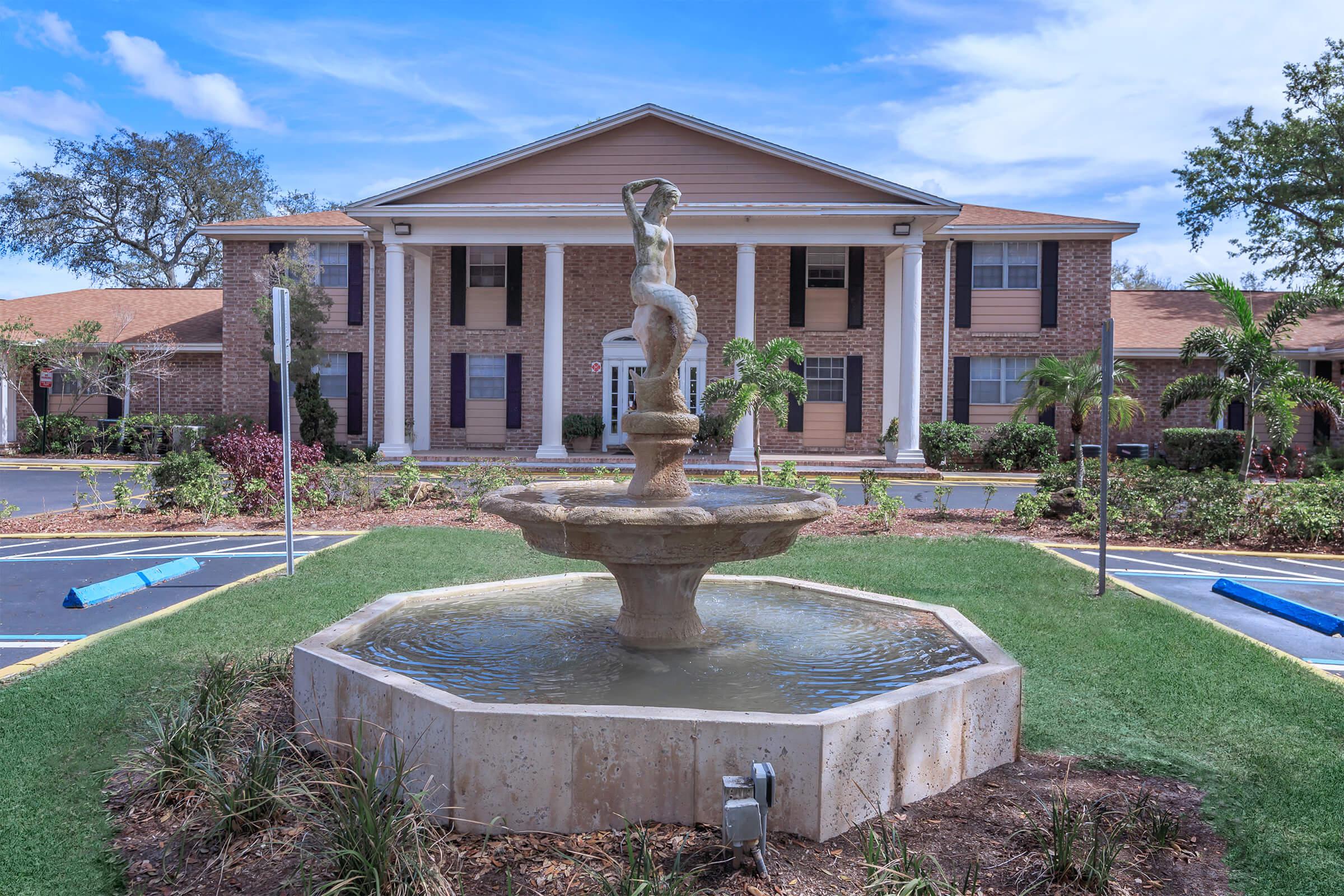 a large brick building with a statue in front of a house