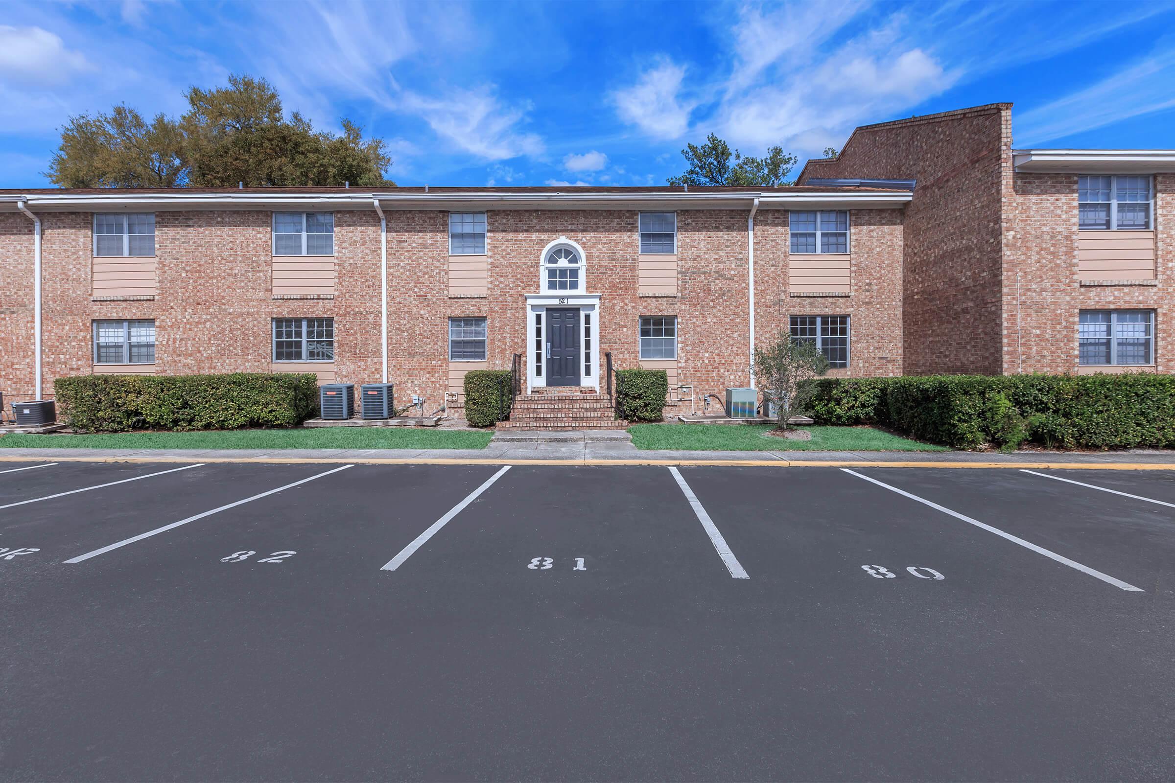 an empty parking lot in front of a brick building