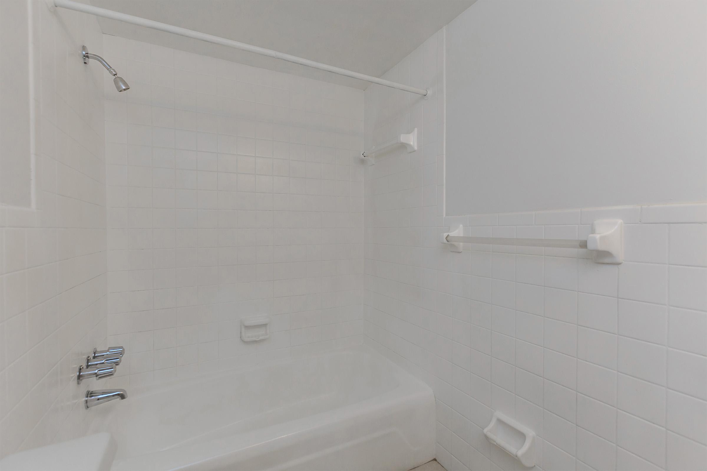 a white tub sitting next to a shower