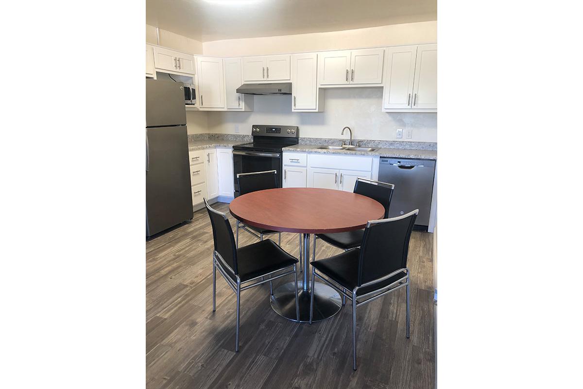 a kitchen with wooden cabinets and a black chair