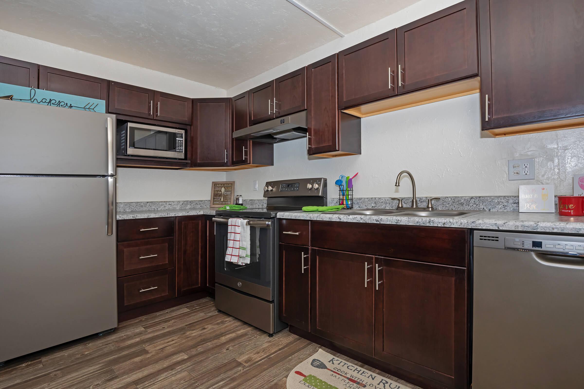 a large kitchen with stainless steel appliances and wooden cabinets