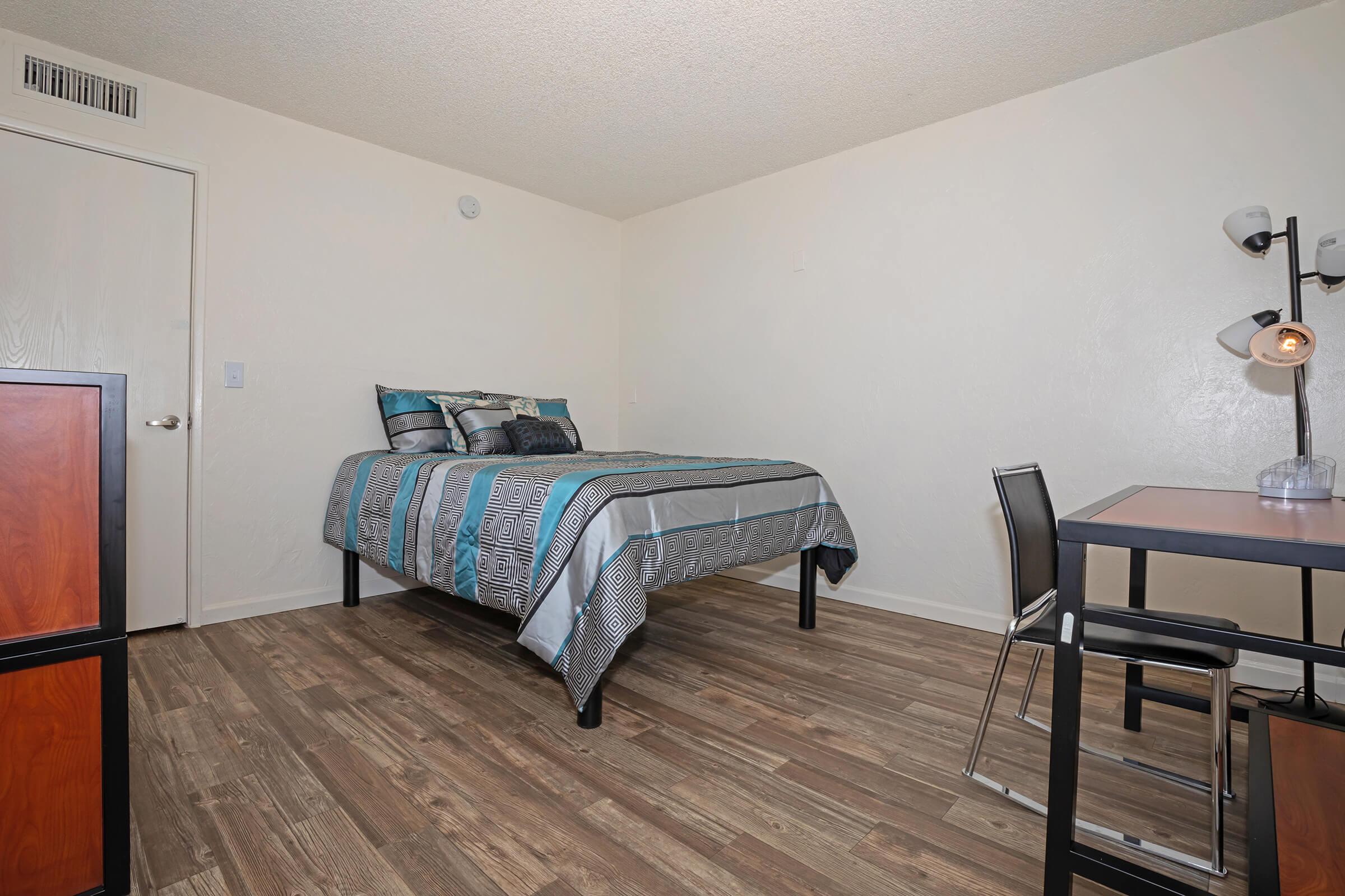 a bedroom with a bed and desk in a room