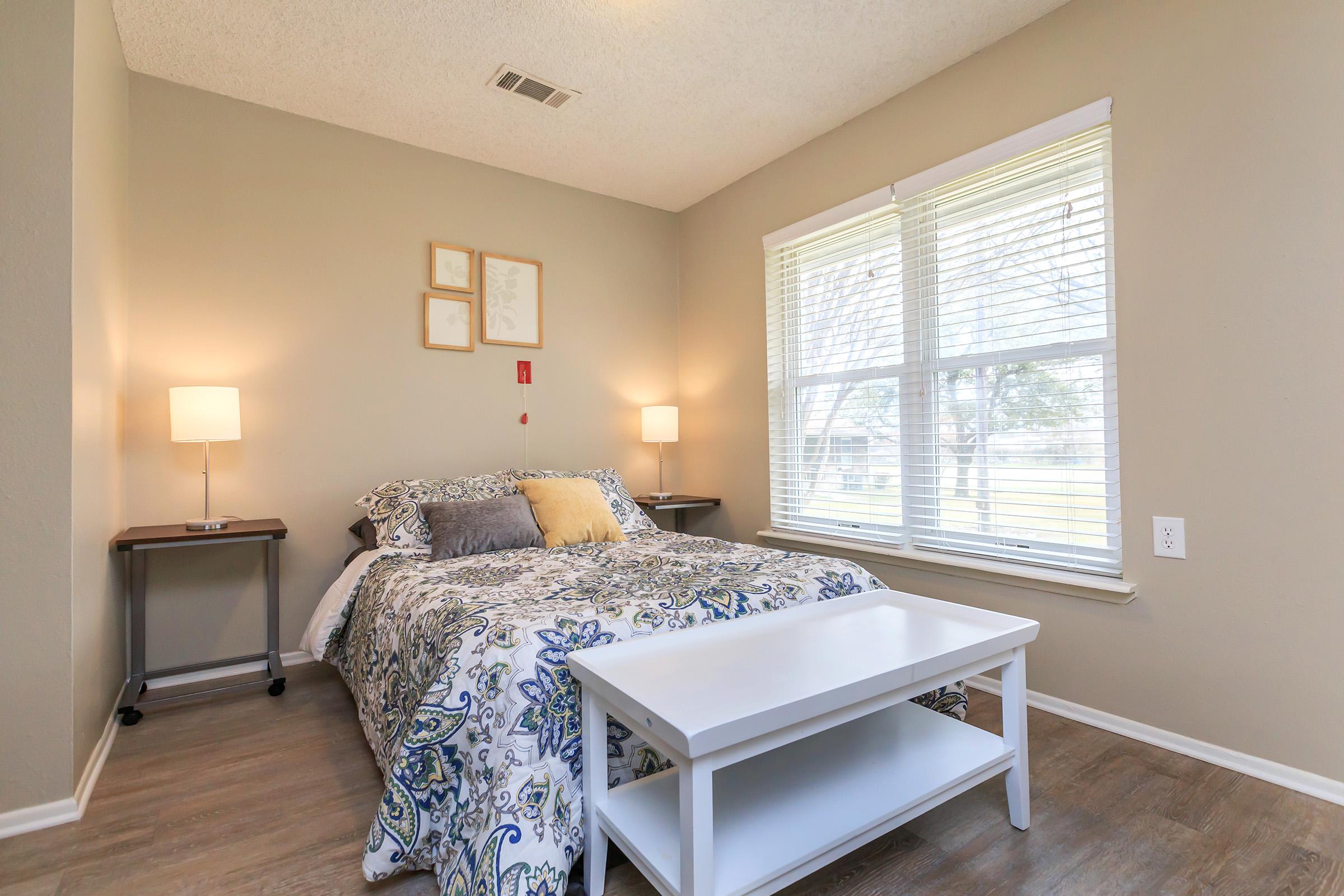 a bedroom with a bed and desk in a room