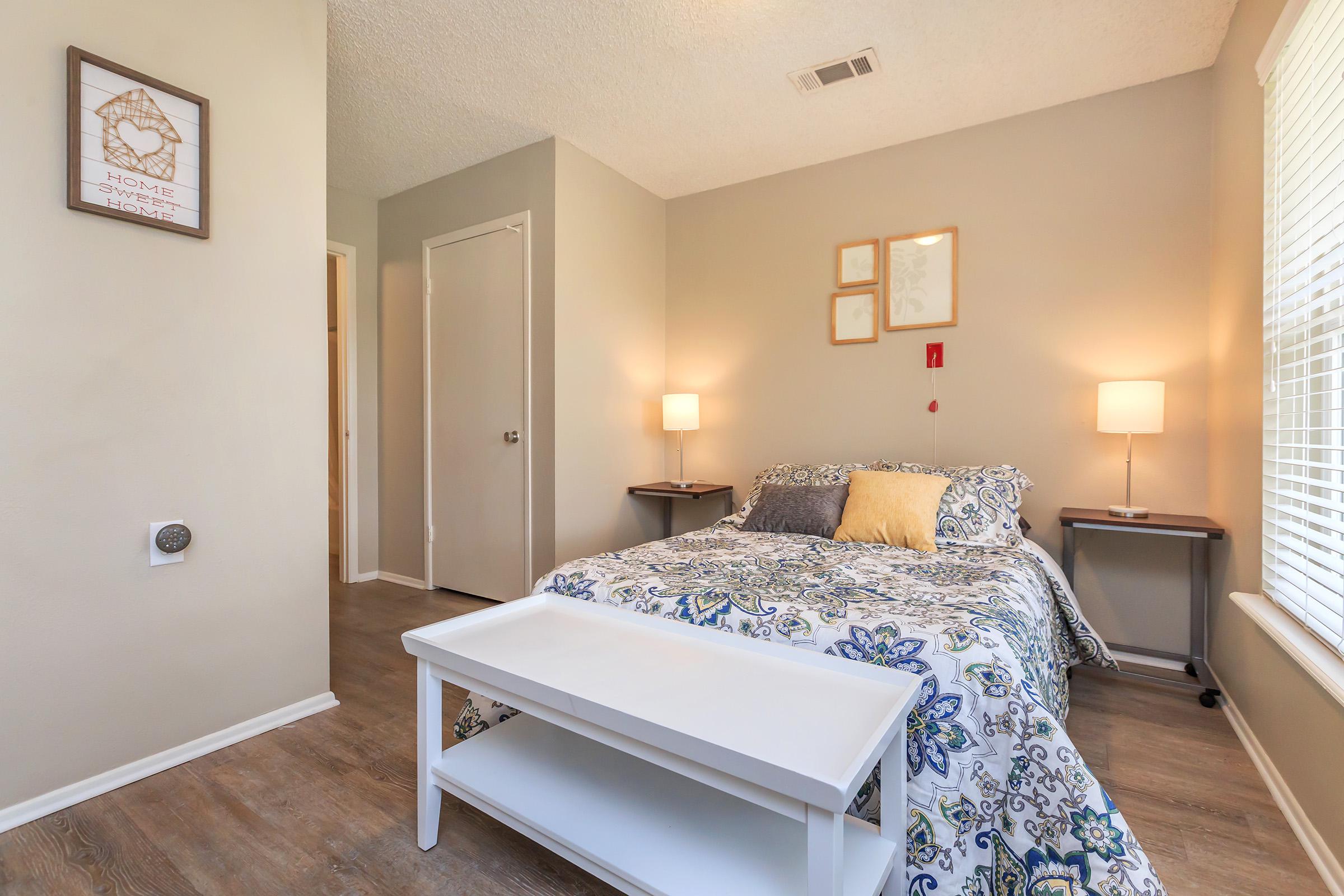 a bedroom with a bed and a mirror in a room