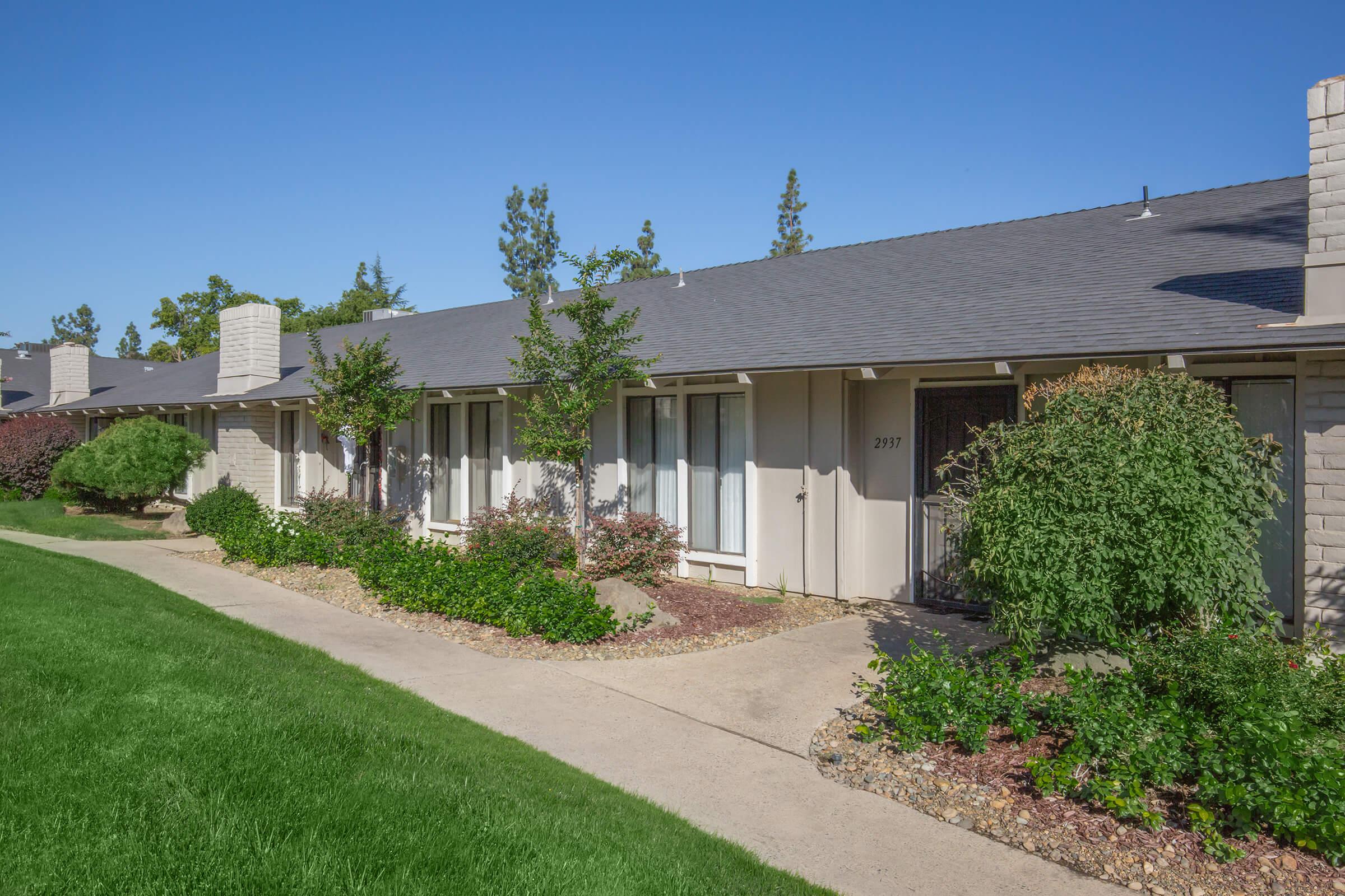 a large brick building with grass in front of a house