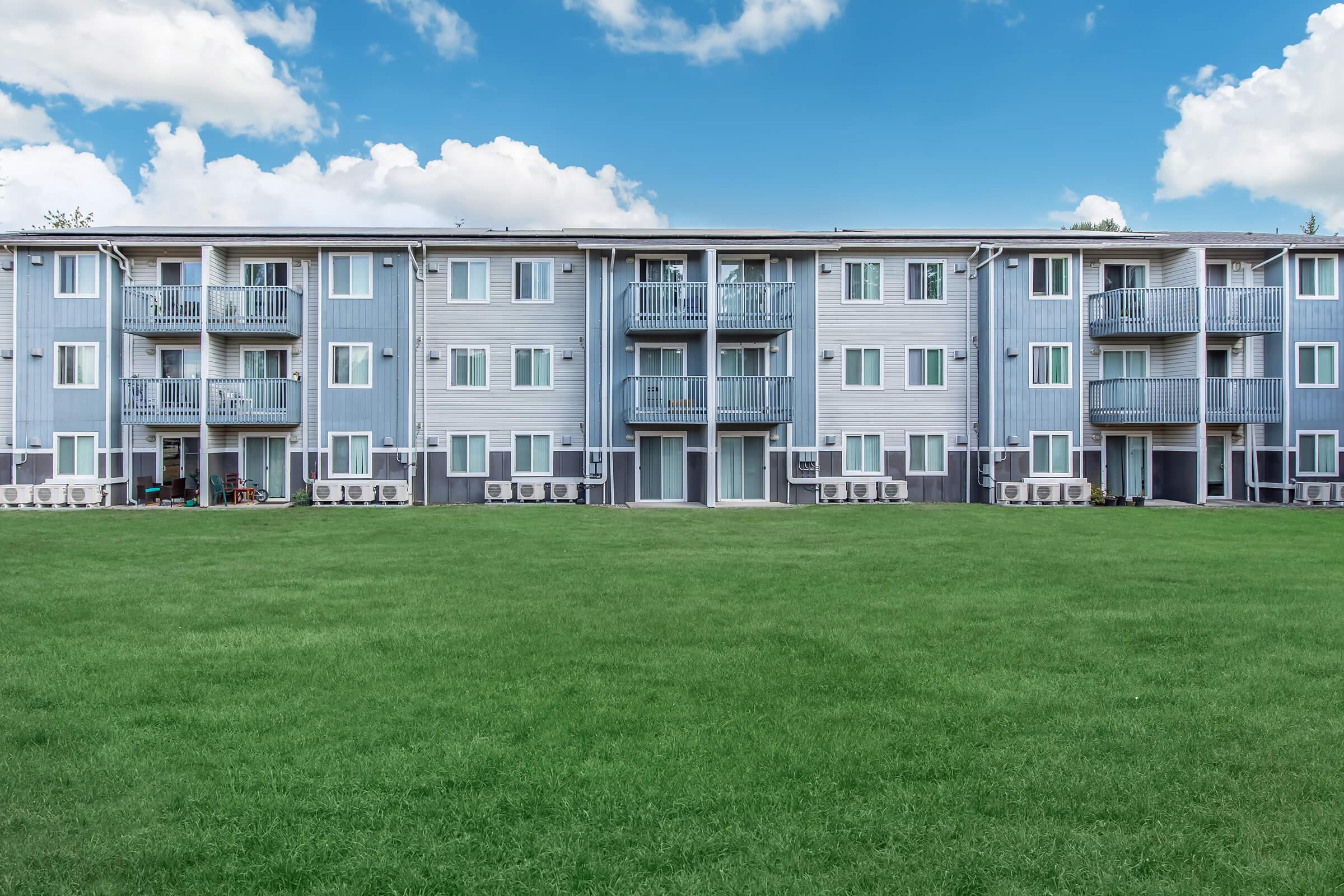 a large green field in front of a building