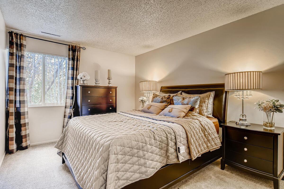 a bedroom with a bed and desk in a room