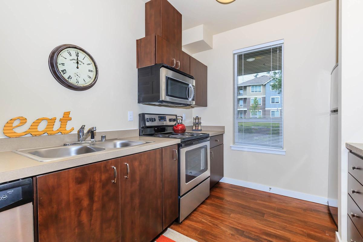 a modern kitchen with stainless steel appliances and wooden cabinets