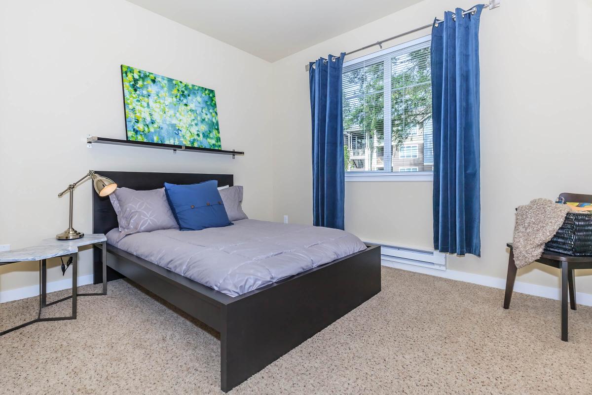 a bedroom with a bed and desk in a room