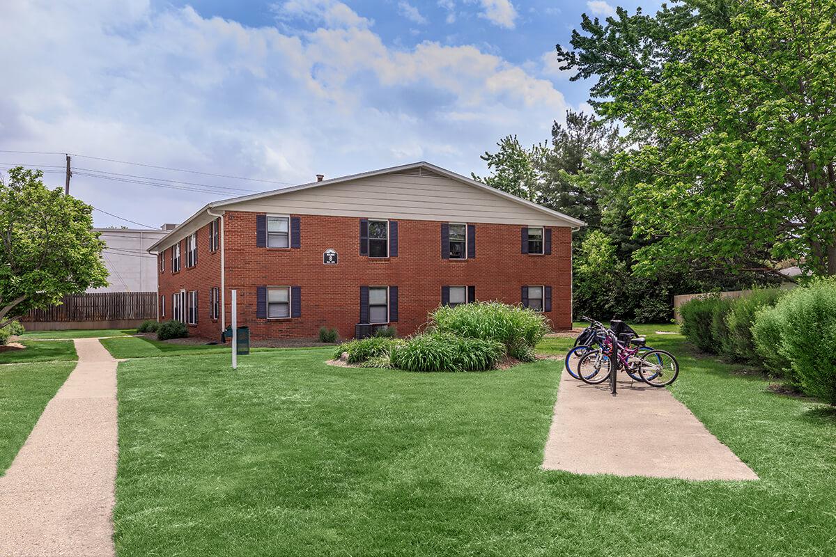 a house with a lawn in front of a brick building