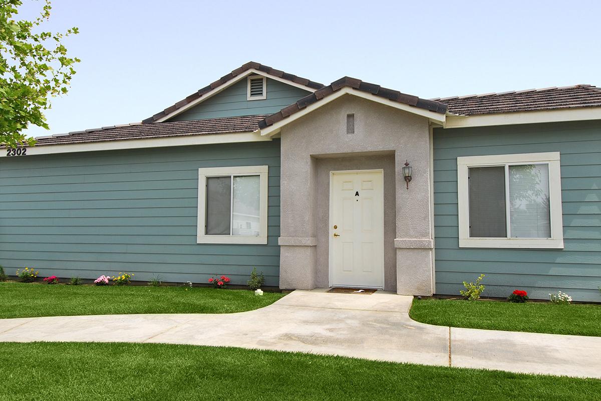 Blue community building with green grass