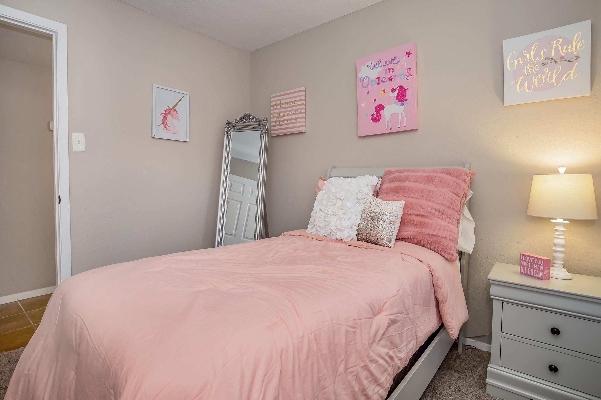 a bedroom with a bed and desk in a room