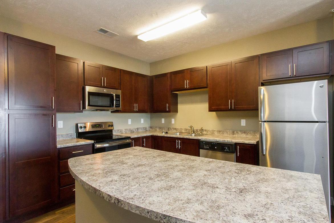 a large kitchen with stainless steel appliances and wooden cabinets