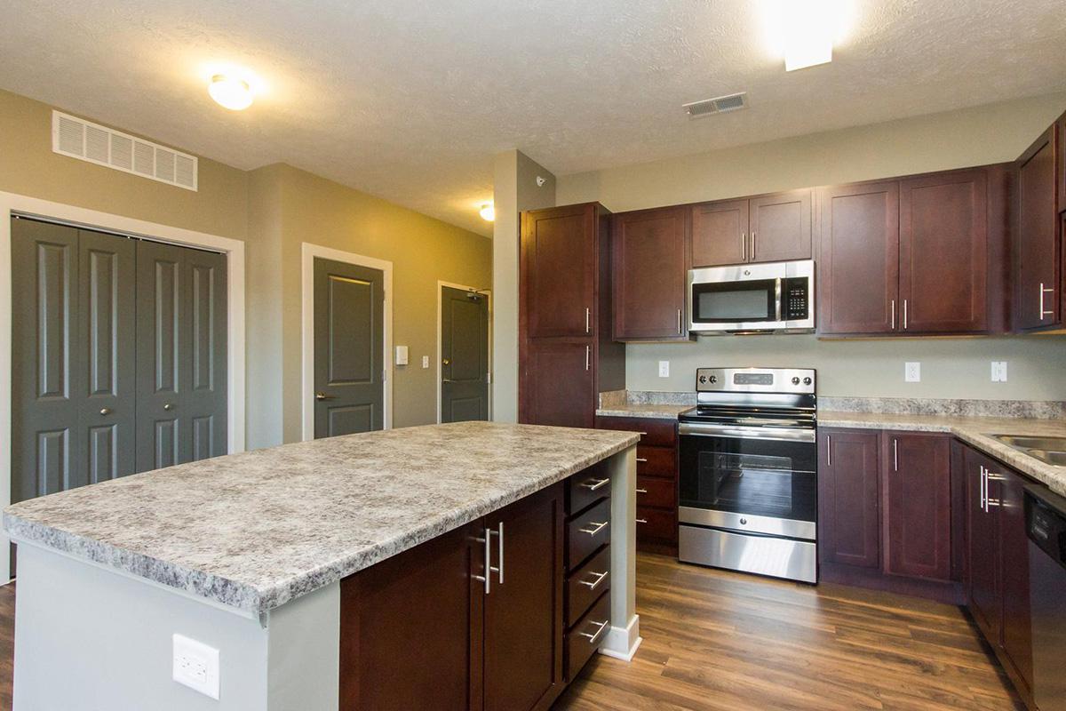 a modern kitchen with stainless steel appliances and wooden cabinets