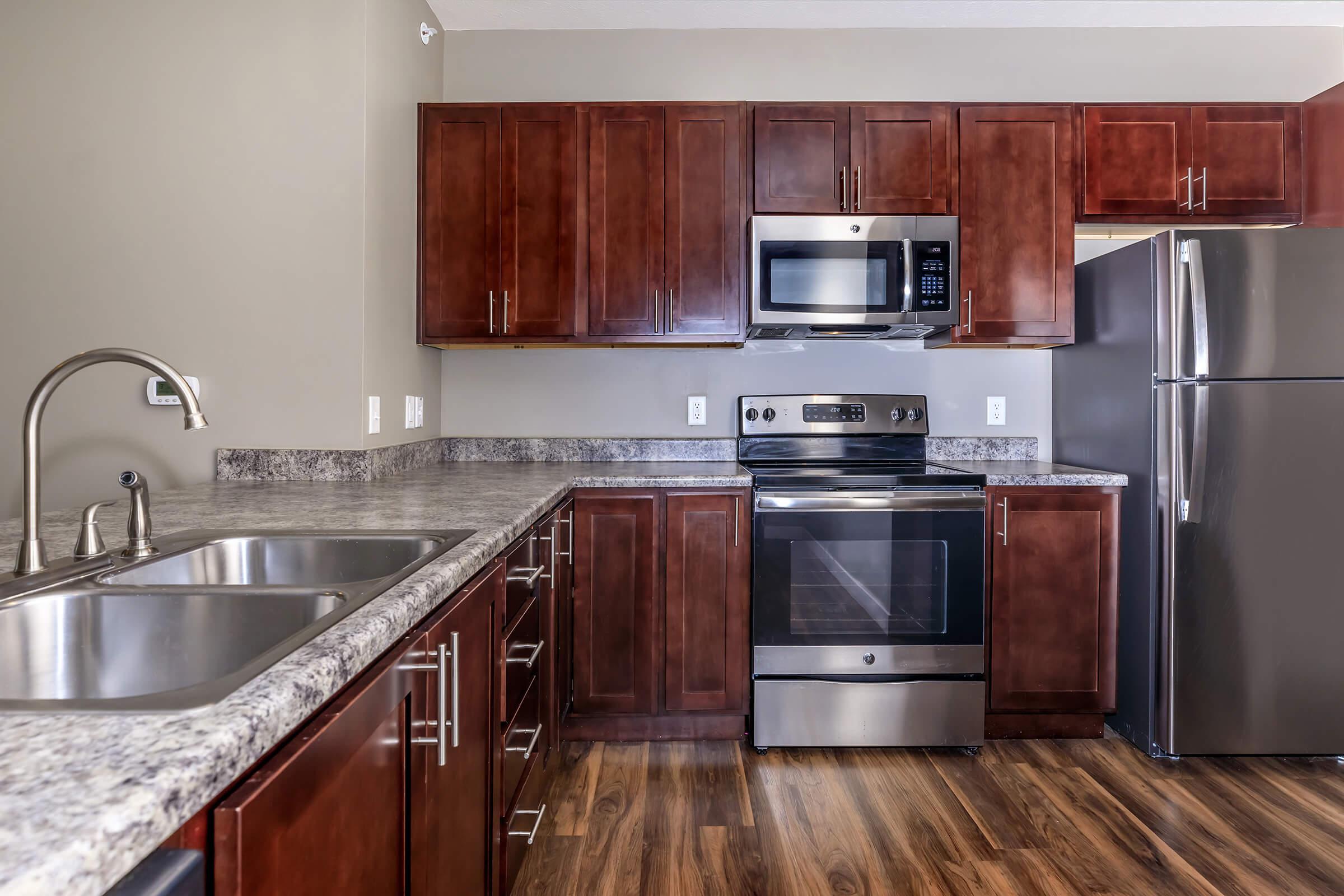 a large kitchen with stainless steel appliances and wooden cabinets