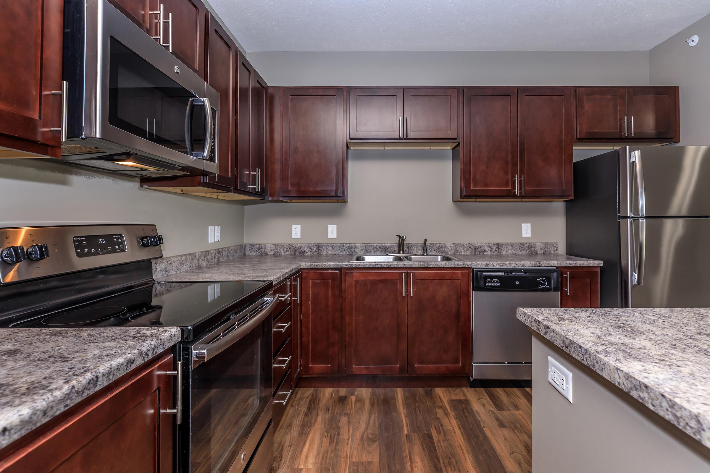 a modern kitchen with stainless steel appliances and wooden cabinets