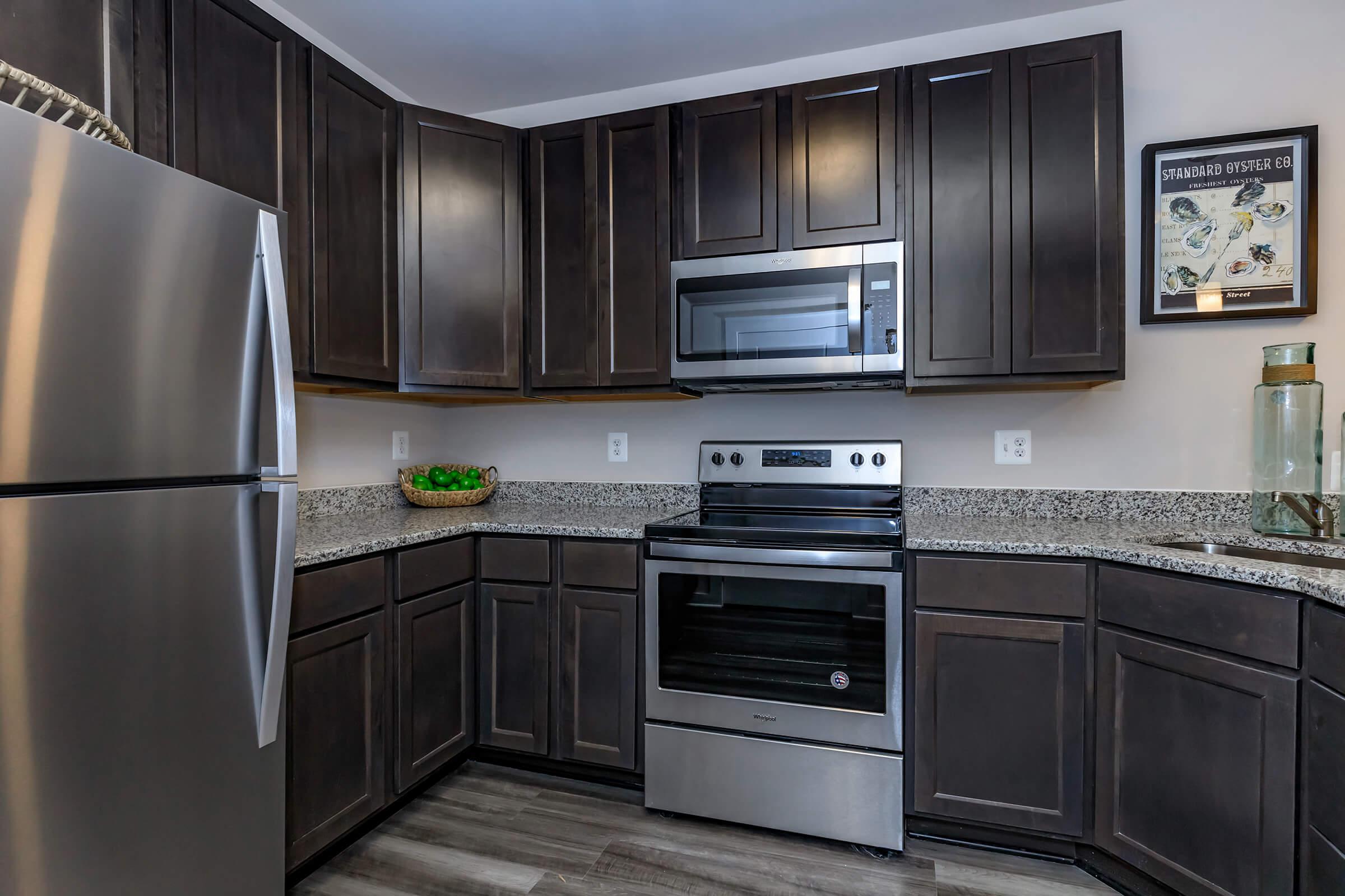 a modern kitchen with stainless steel appliances and wooden cabinets