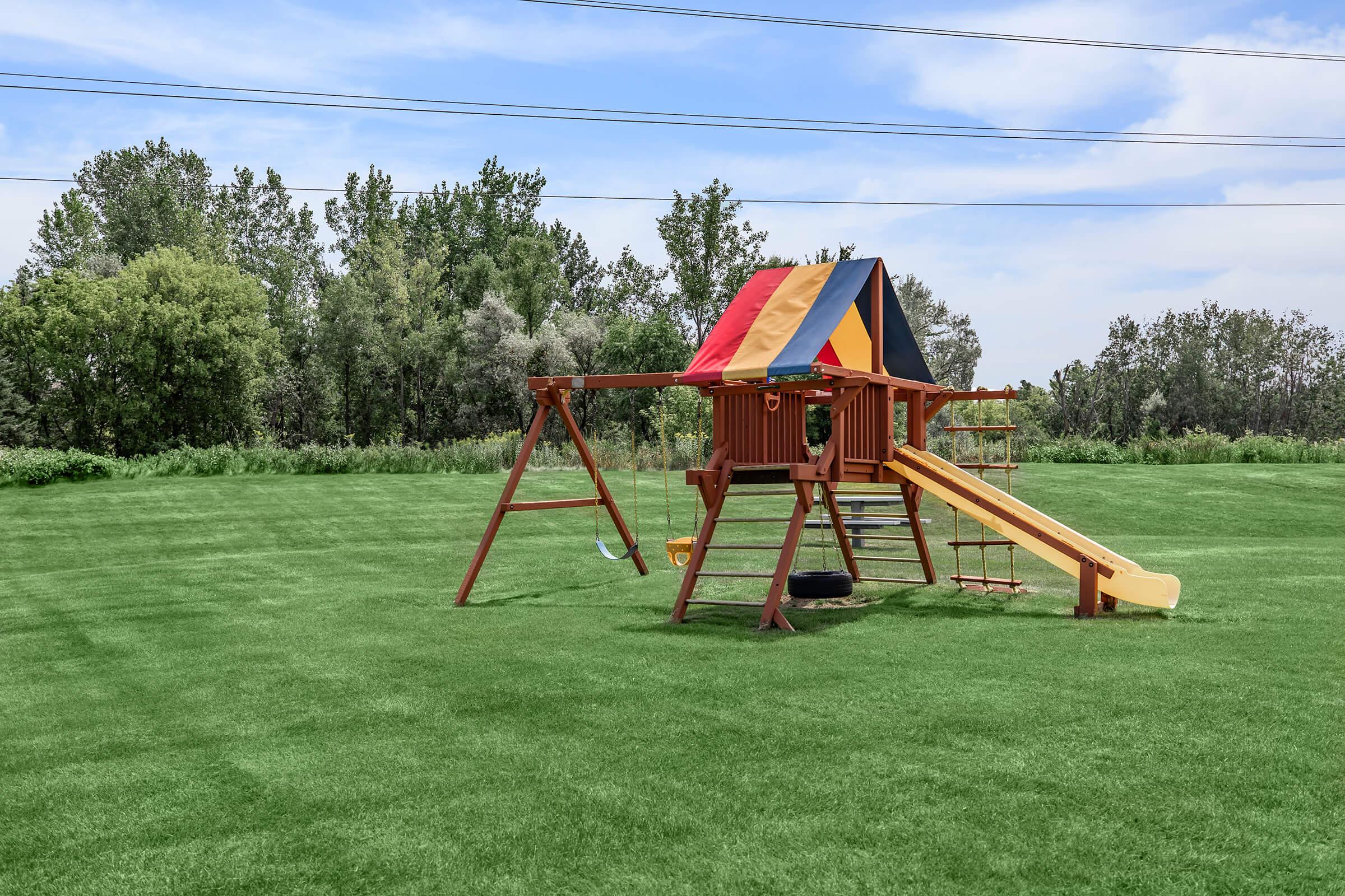 a couple of lawn chairs sitting on top of a grass covered field