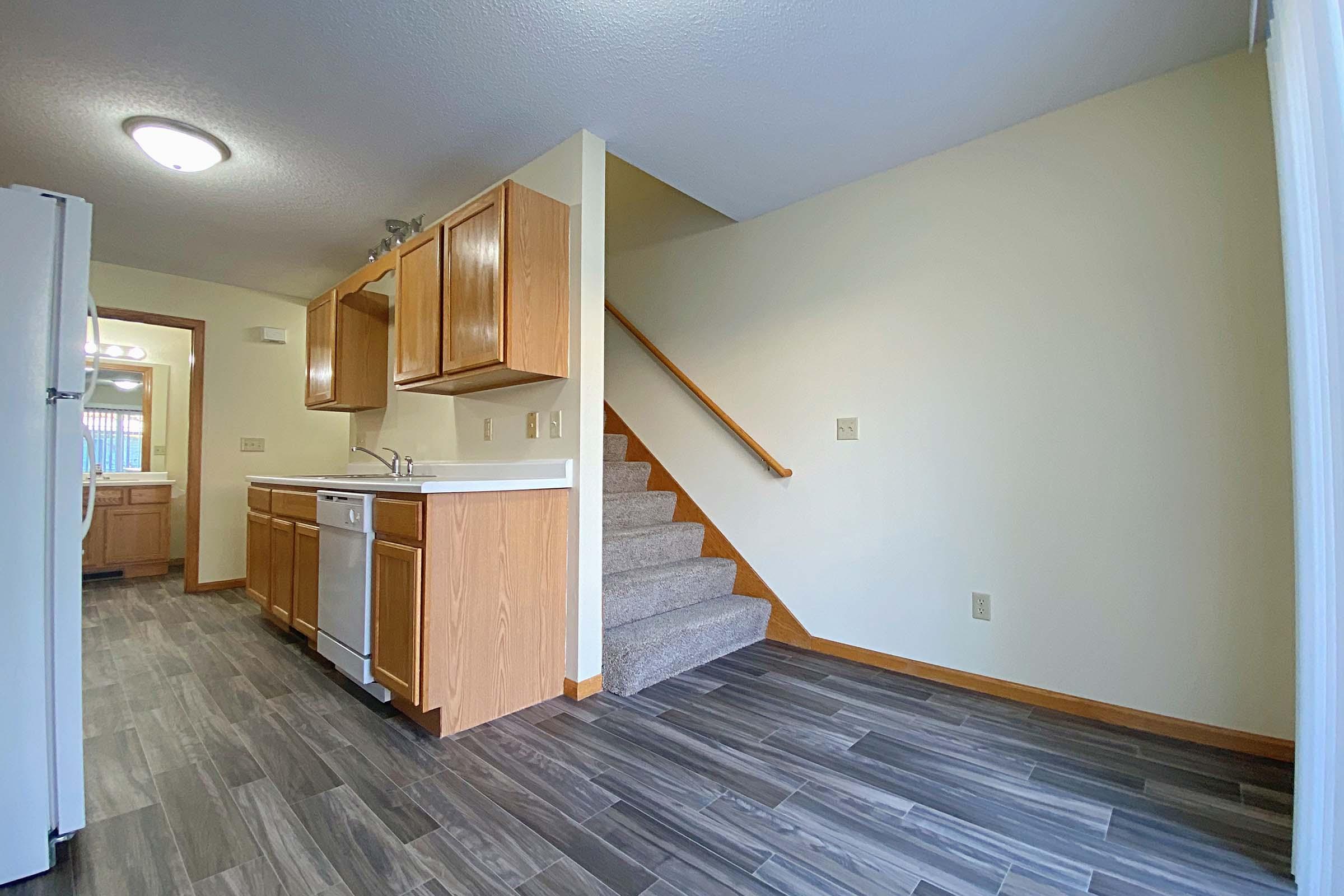 a kitchen with wooden cabinets and a wood floor