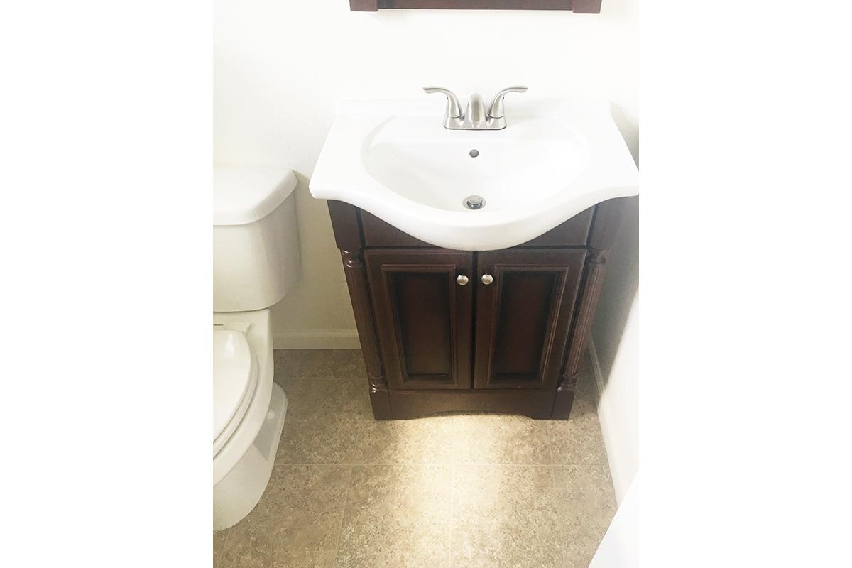 a white sink sitting under a mirror