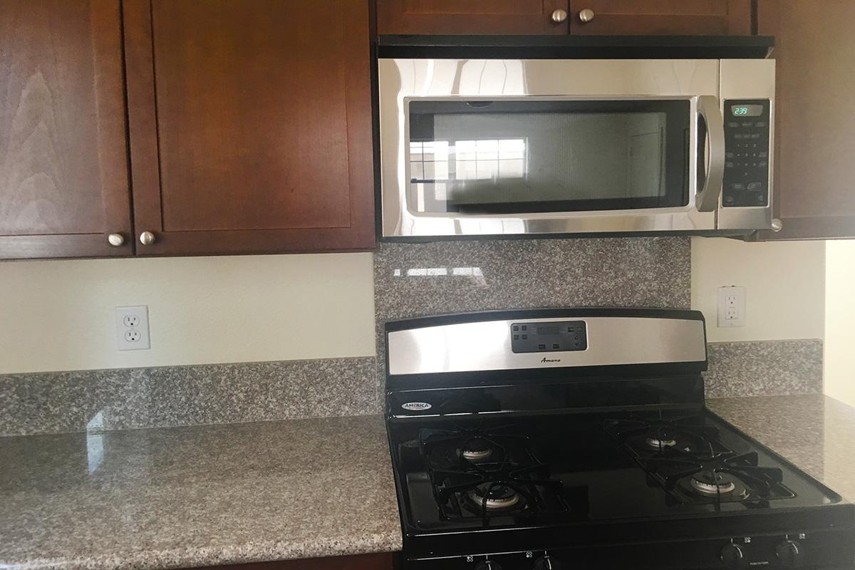 a black stove top oven sitting inside of a kitchen