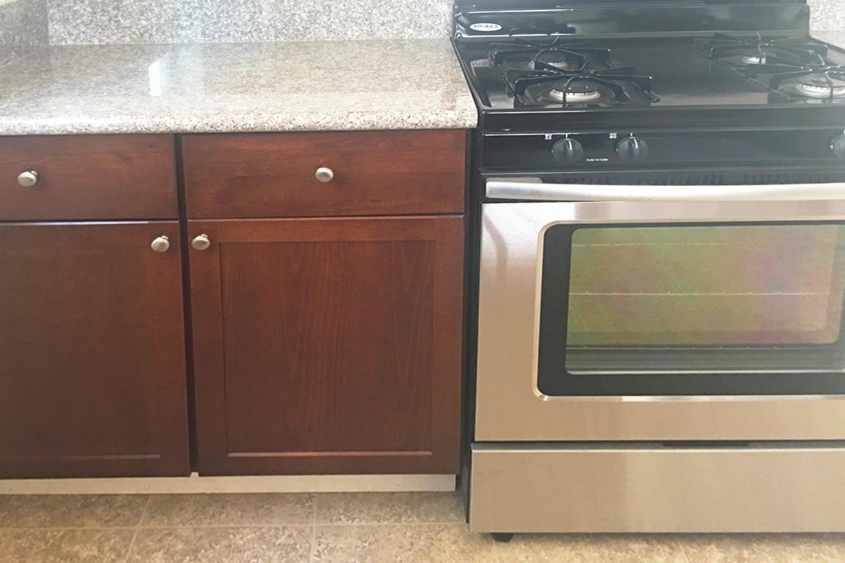 a stove top oven sitting inside of a kitchen