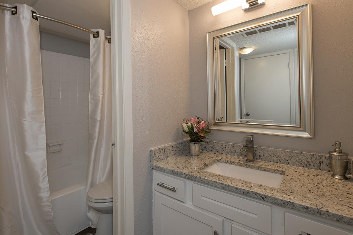 a white sink sitting next to a shower