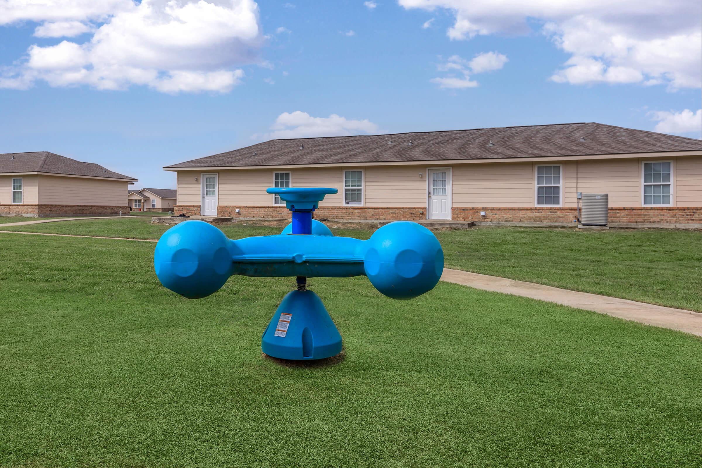 a small blue plane sitting on top of a grass covered field