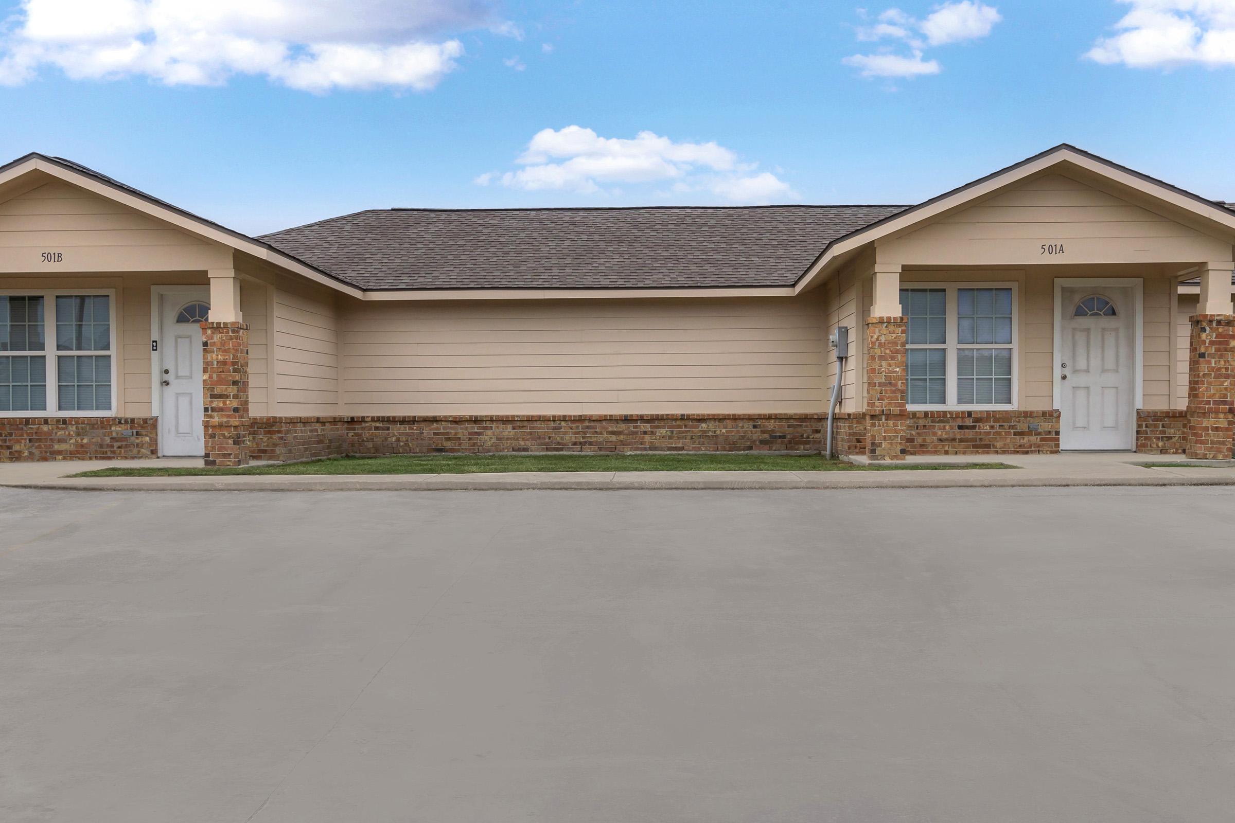 an empty parking lot in front of a house