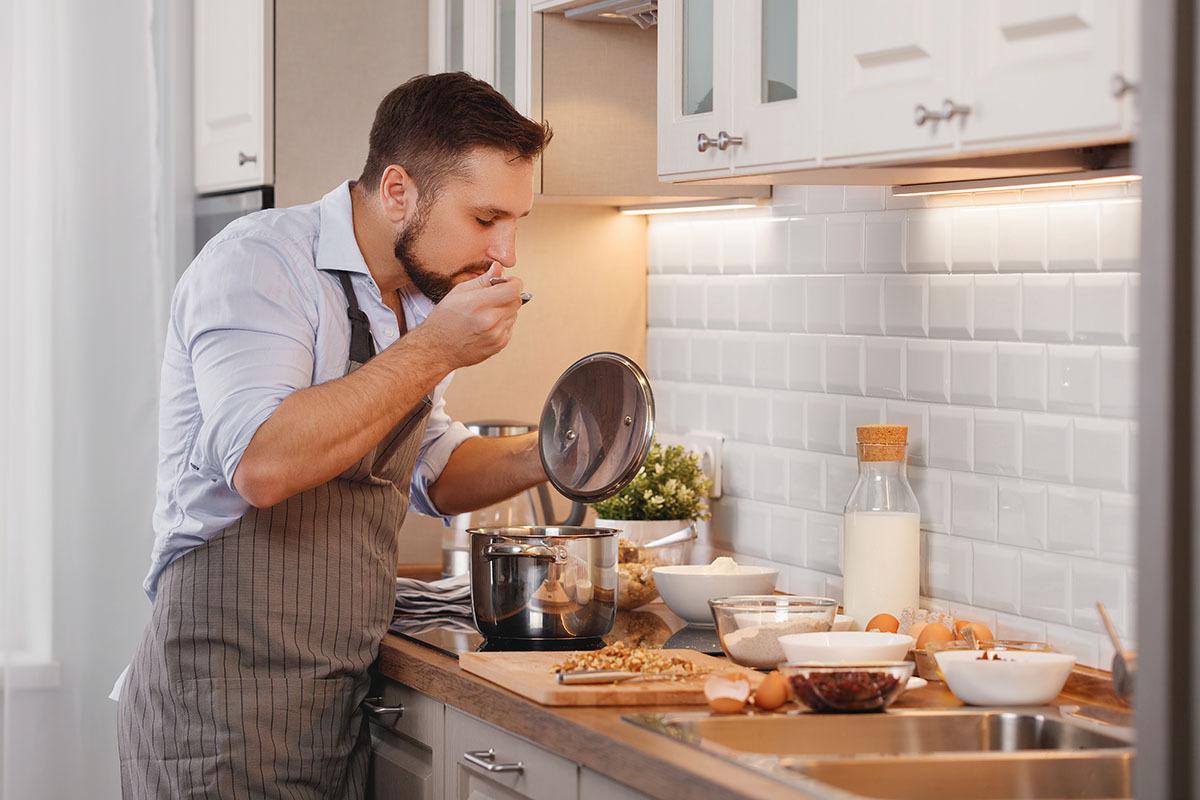 a man standing in a kitchen preparing food
