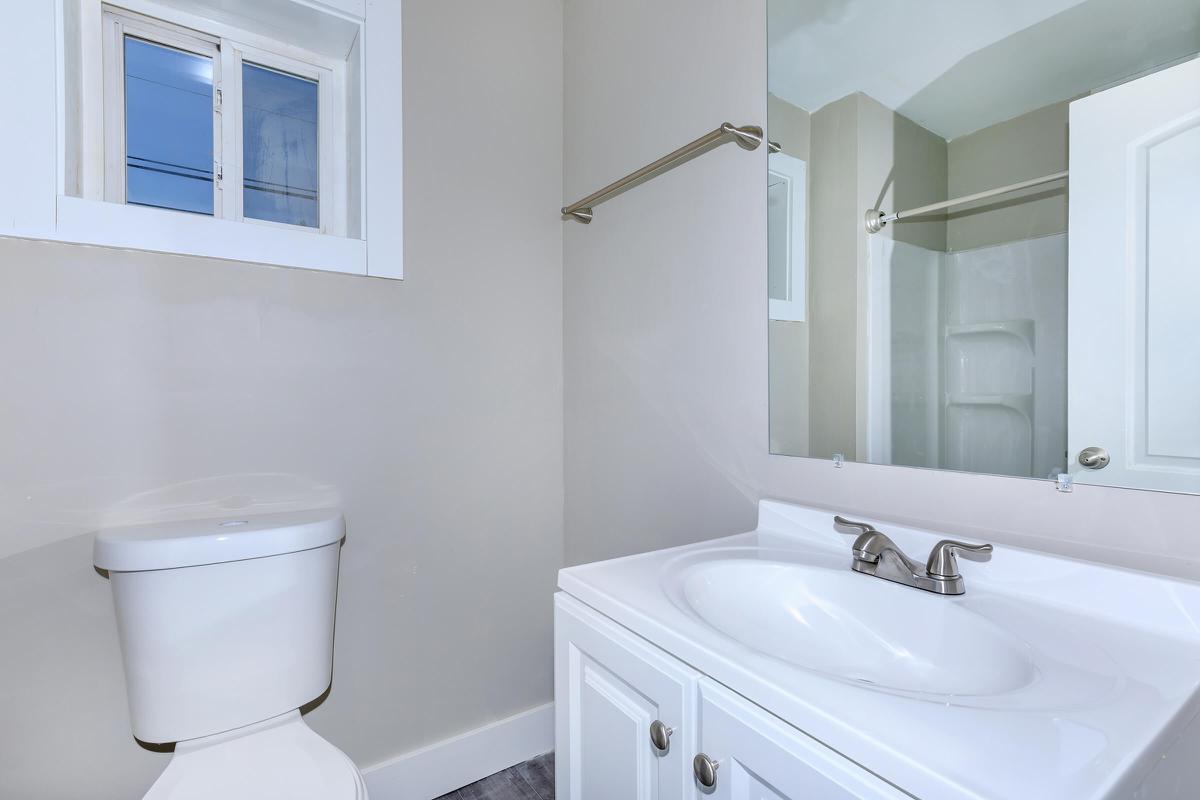 a white sink sitting under a mirror