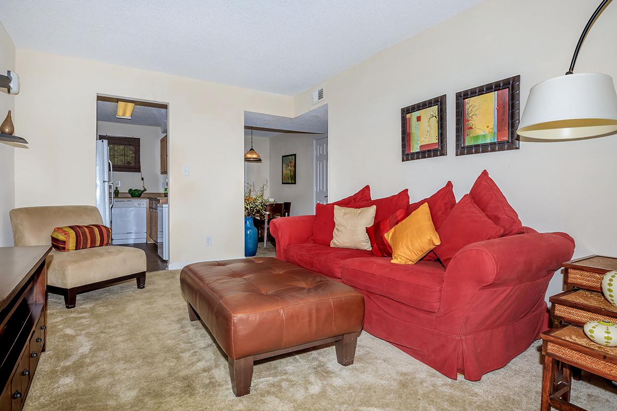 a living room filled with furniture and a red leather couch