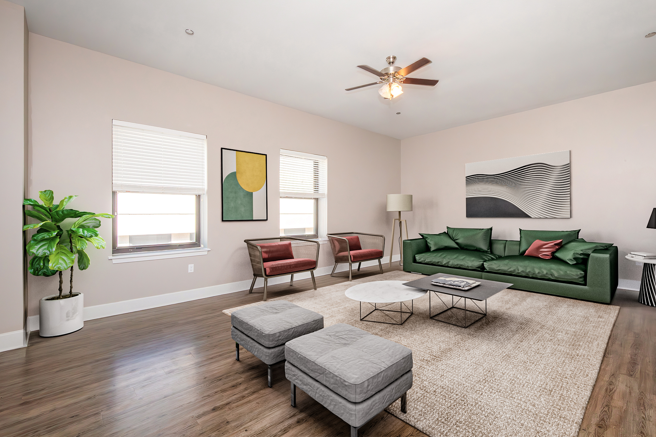A modern living room featuring a green sofa, two red accent chairs, a round coffee table, and two gray ottomans. The room has light-colored walls, large windows with closed blinds, a ceiling fan, and a decorative plant in a white pot. Abstract artwork adorns the walls, contributing to a stylish, cozy atmosphere.