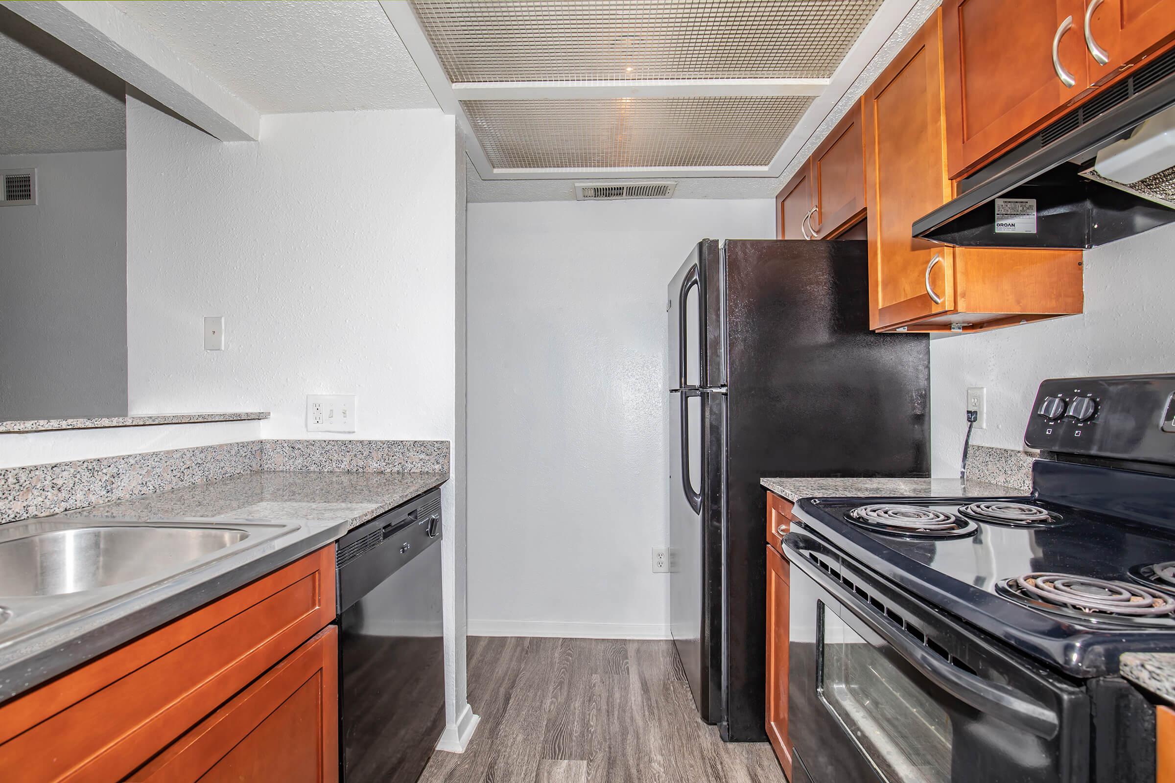 a large kitchen with stainless steel appliances and wooden cabinets