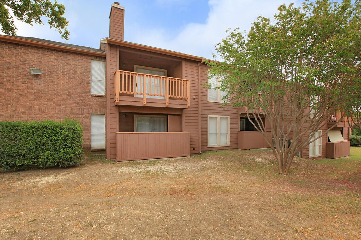 a large brick building with grass in front of a house