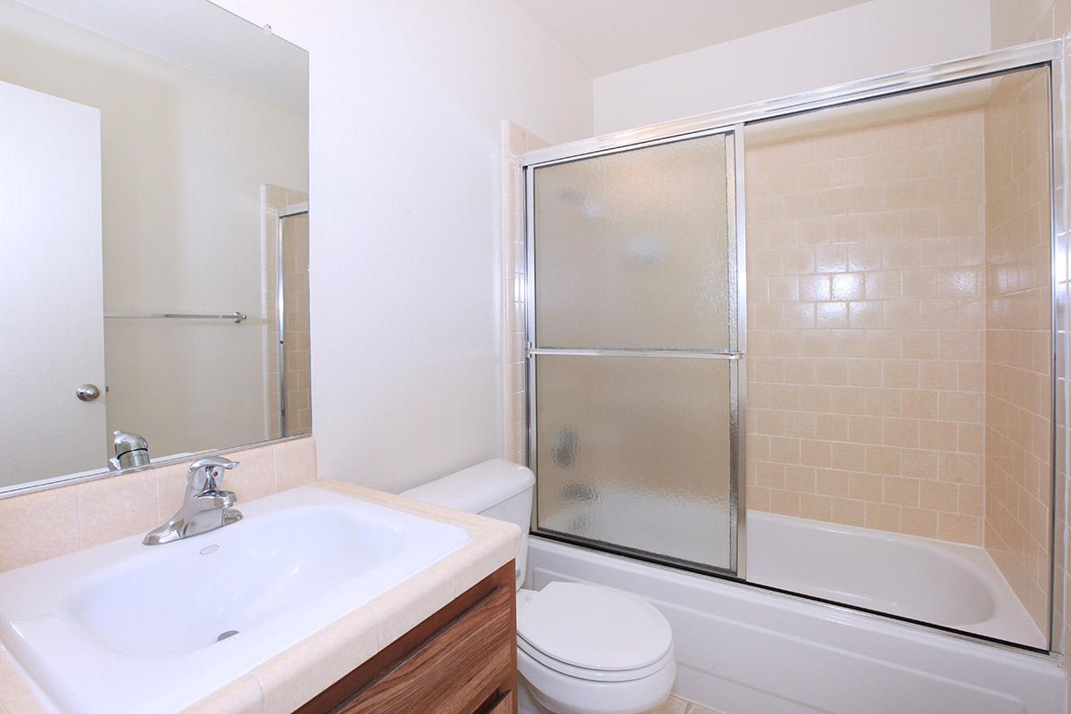 a white sink sitting next to a glass shower door