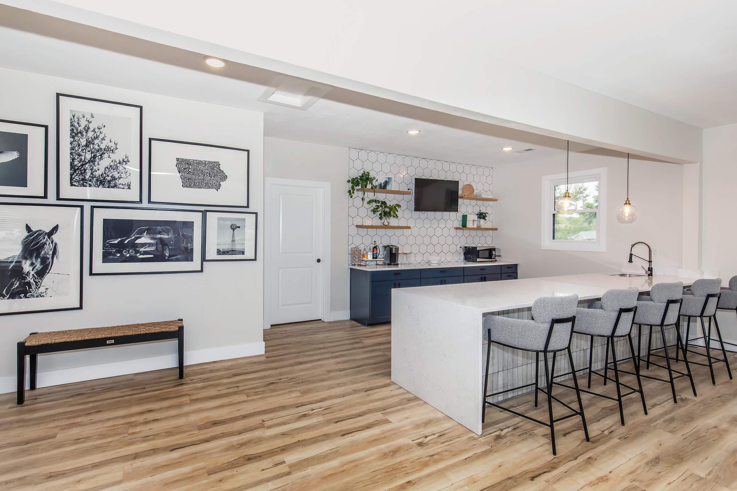 Clubhouse interior with quartz island, modern lighting, and seating areas at Bexley Apartments.