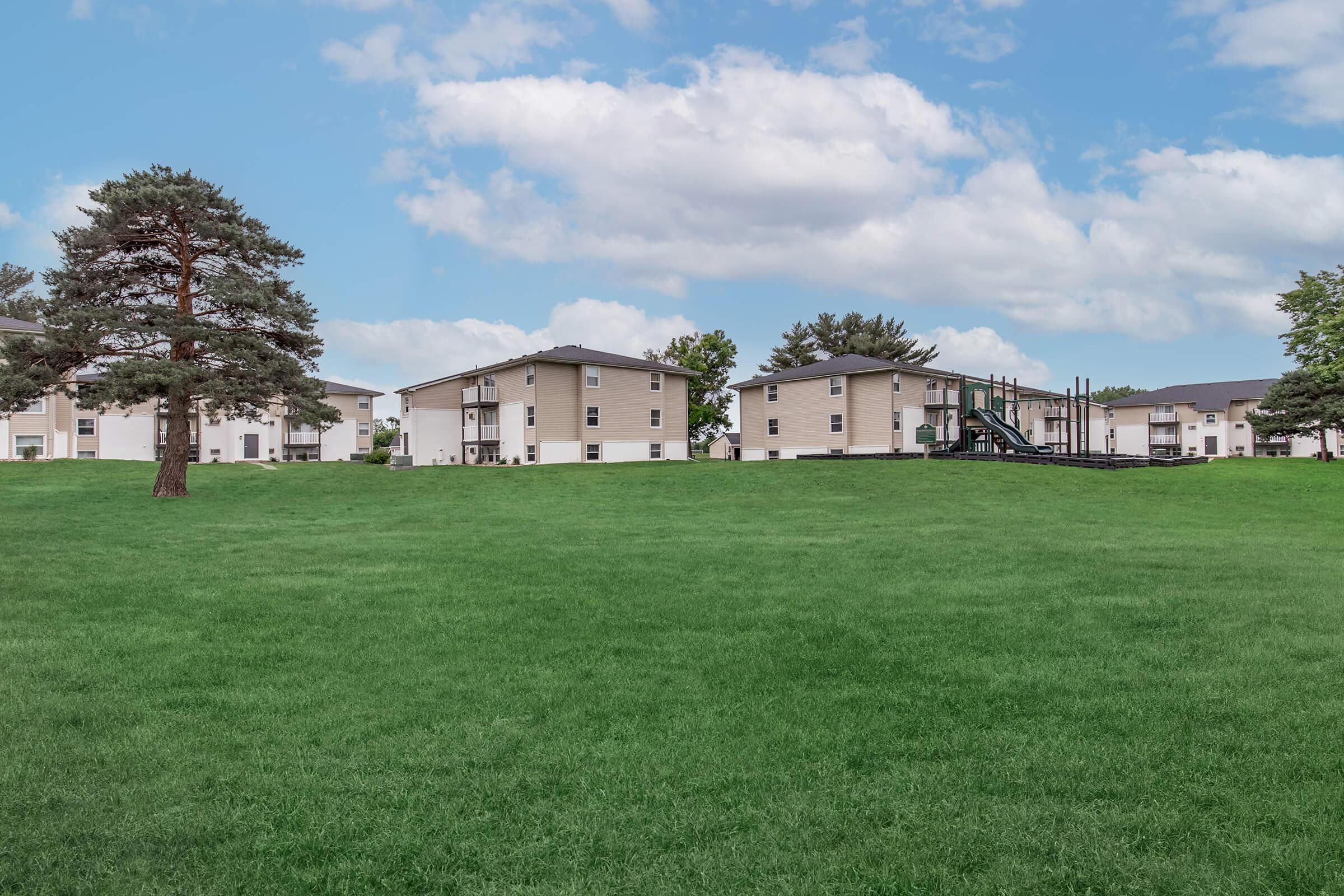 Open lawn and surrounding buildings at Bexley Apartments in the Urbandale School District.