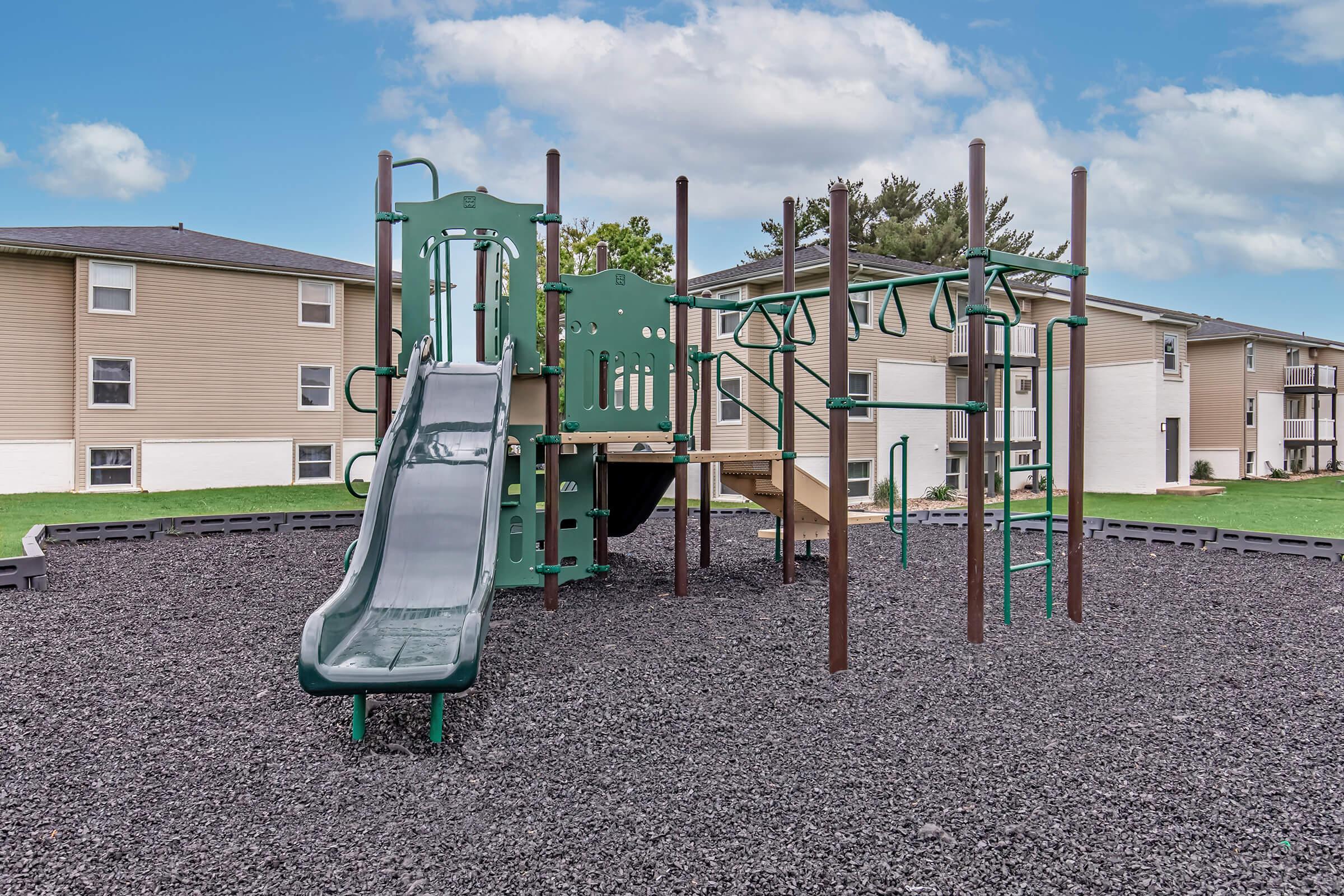 On-site playground with slide and climbing features in family-friendly Bexley apartment community.