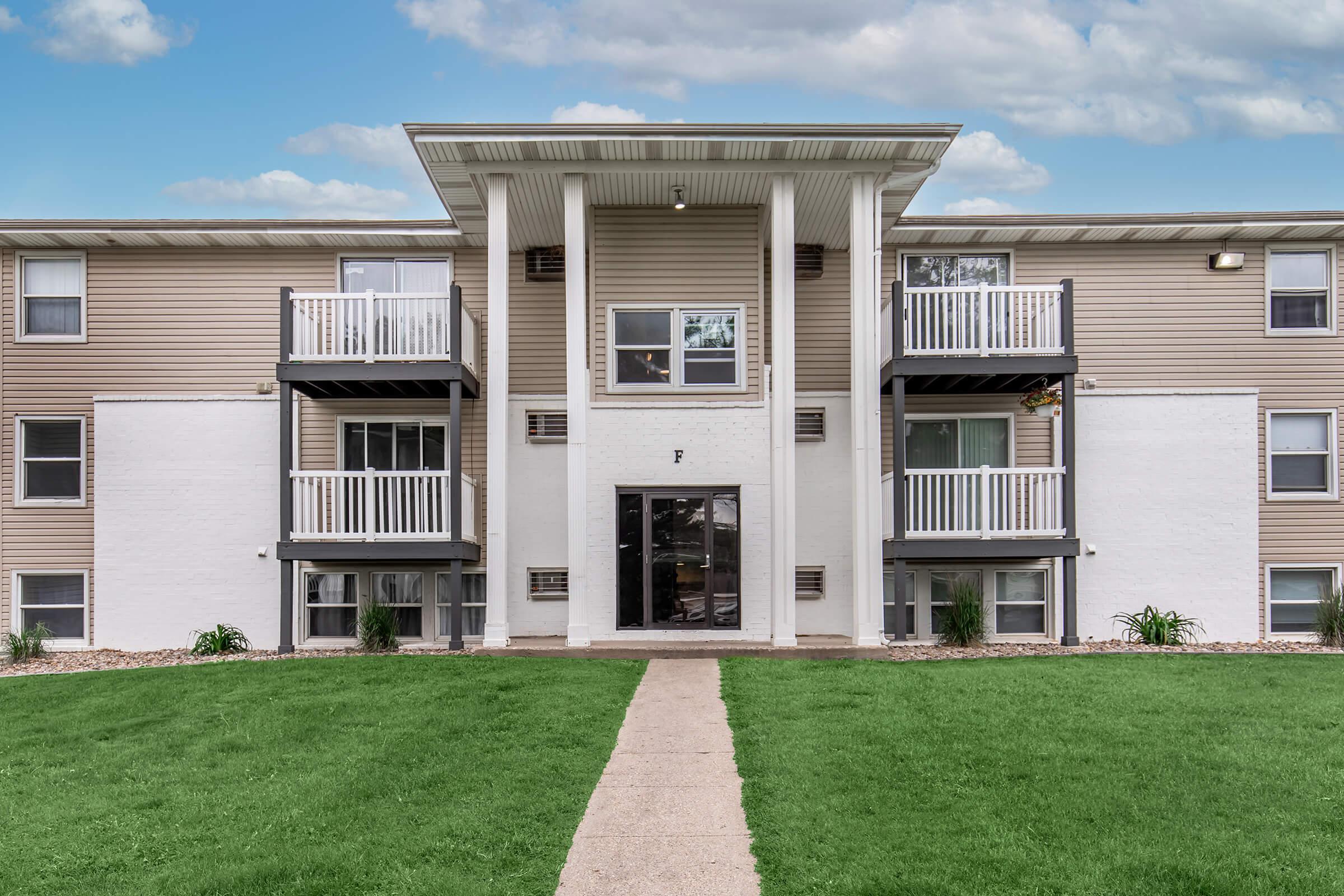 Three-story apartment building with balconies and stone columns in Bexley Urbandale.