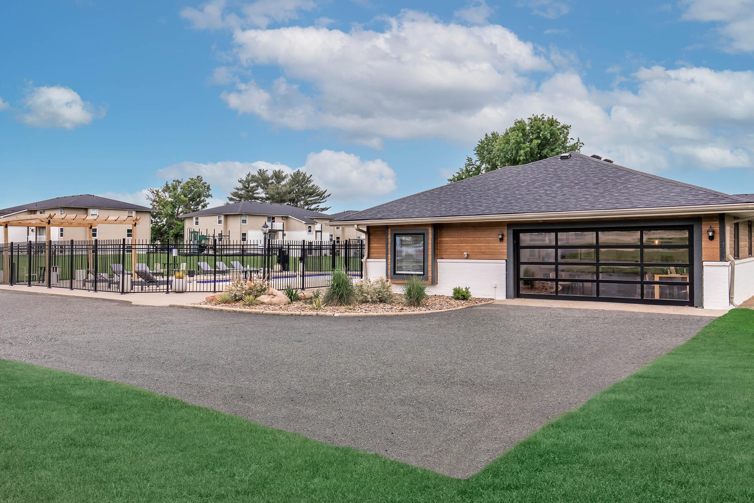 Outdoor view of pool, clubhouse, and parking area at Bexley Apartments near Des Moines.