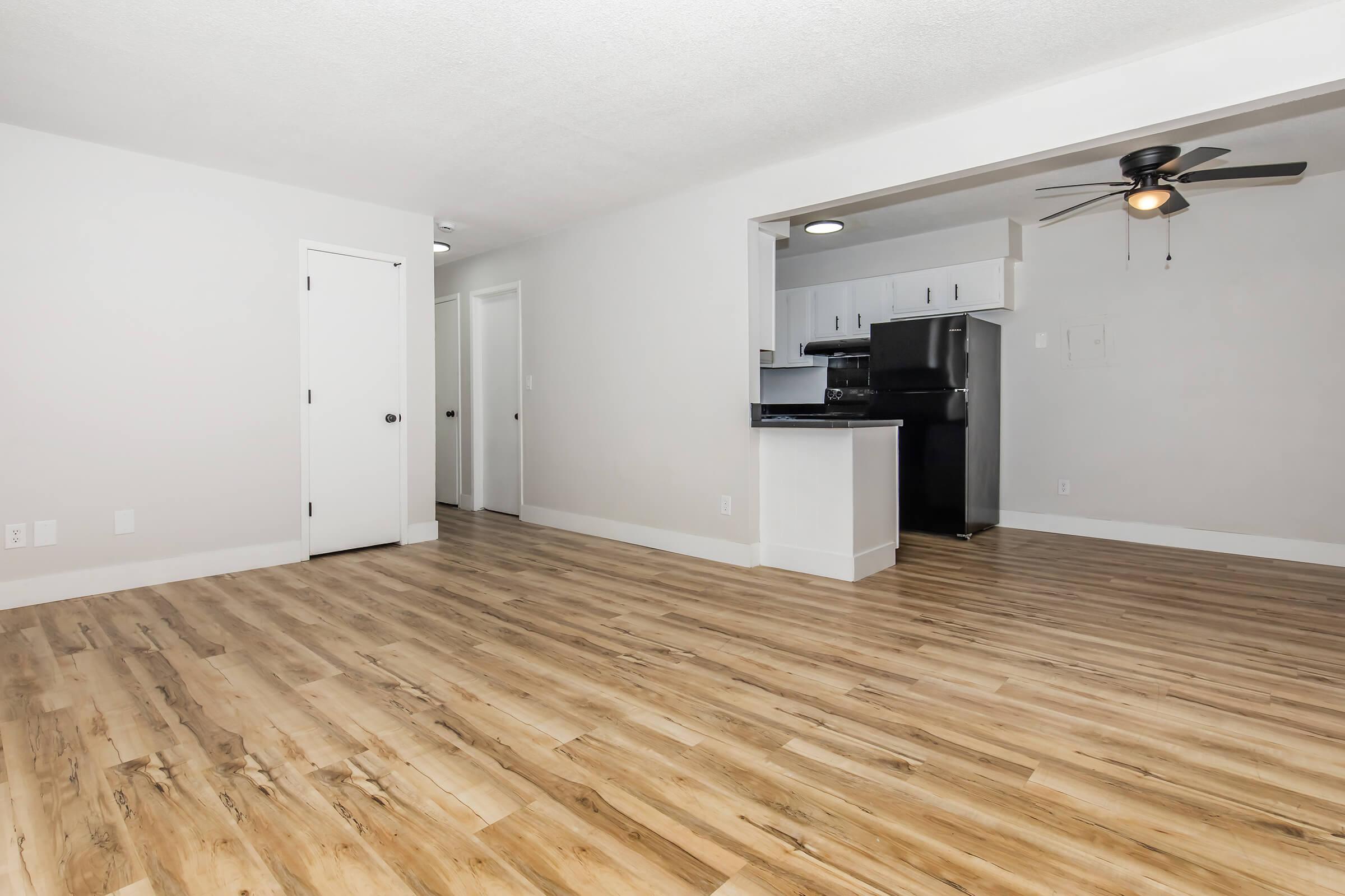 Open floor plan with combined living and dining area and a view into the kitchen at Bexley Apartments.