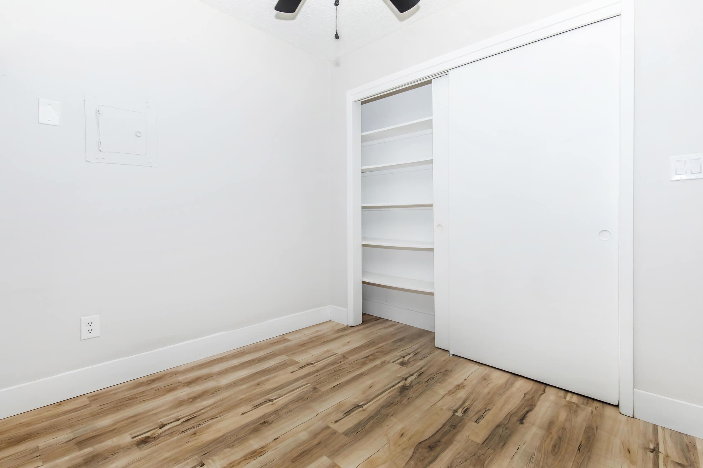 Bedroom closet with sliding doors and built-in shelving in a renovated apartment at Bexley Urbandale.