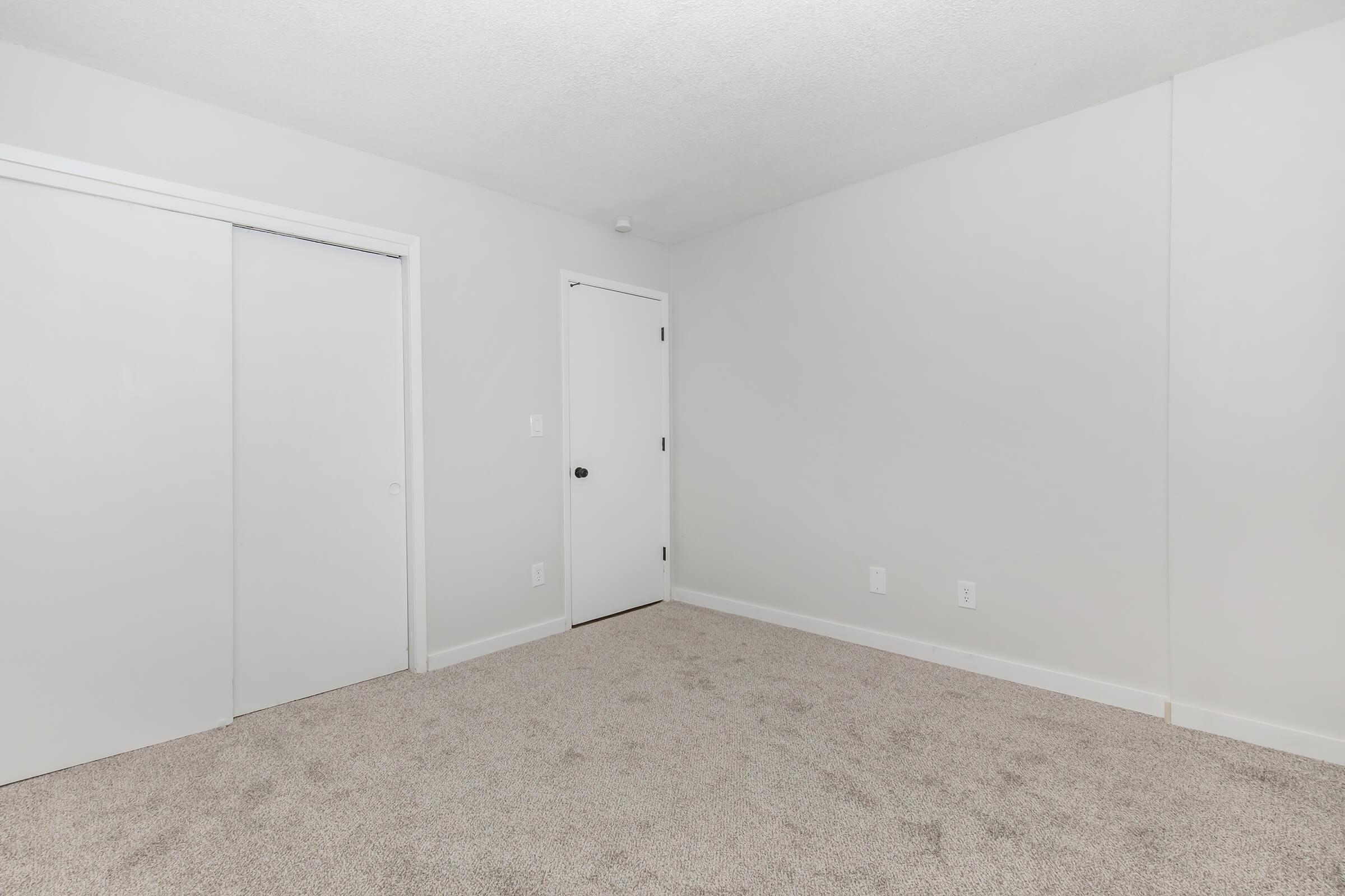 Renovated bedroom with white walls, closed closet doors, and textured ceiling in Bexley 1-bedroom apartment.