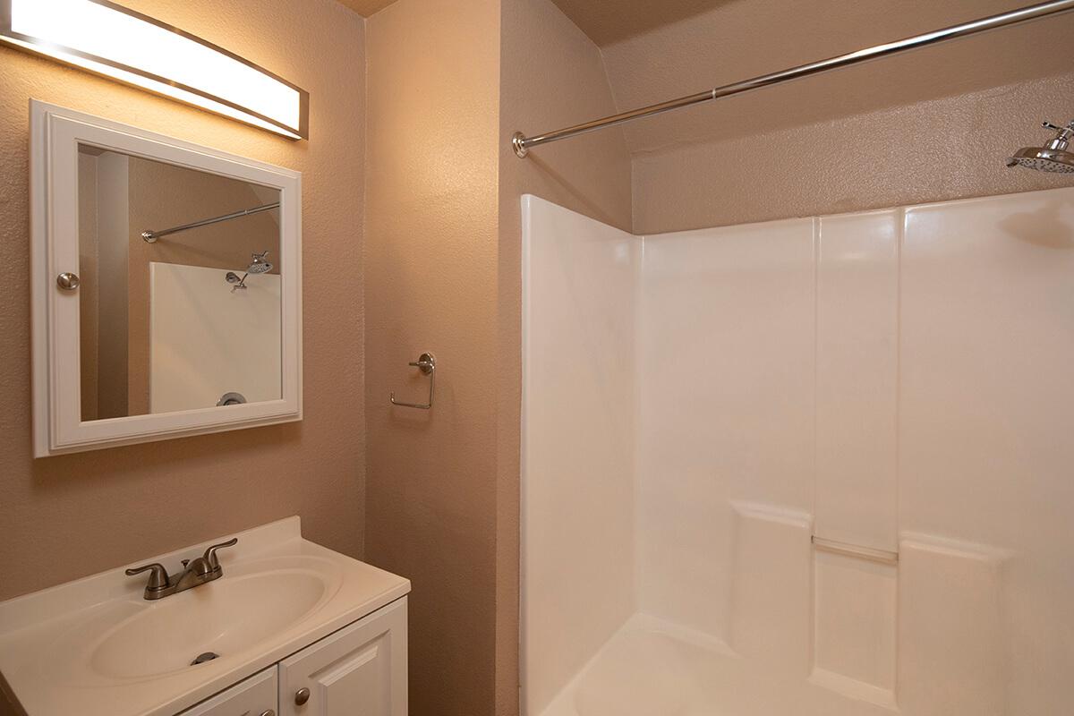 a white sink sitting under a mirror