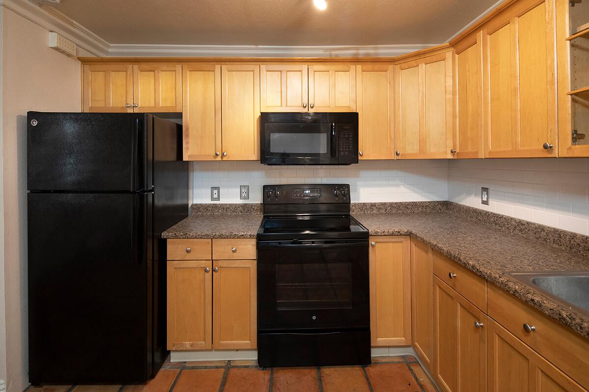 a kitchen with stainless steel appliances and wooden cabinets